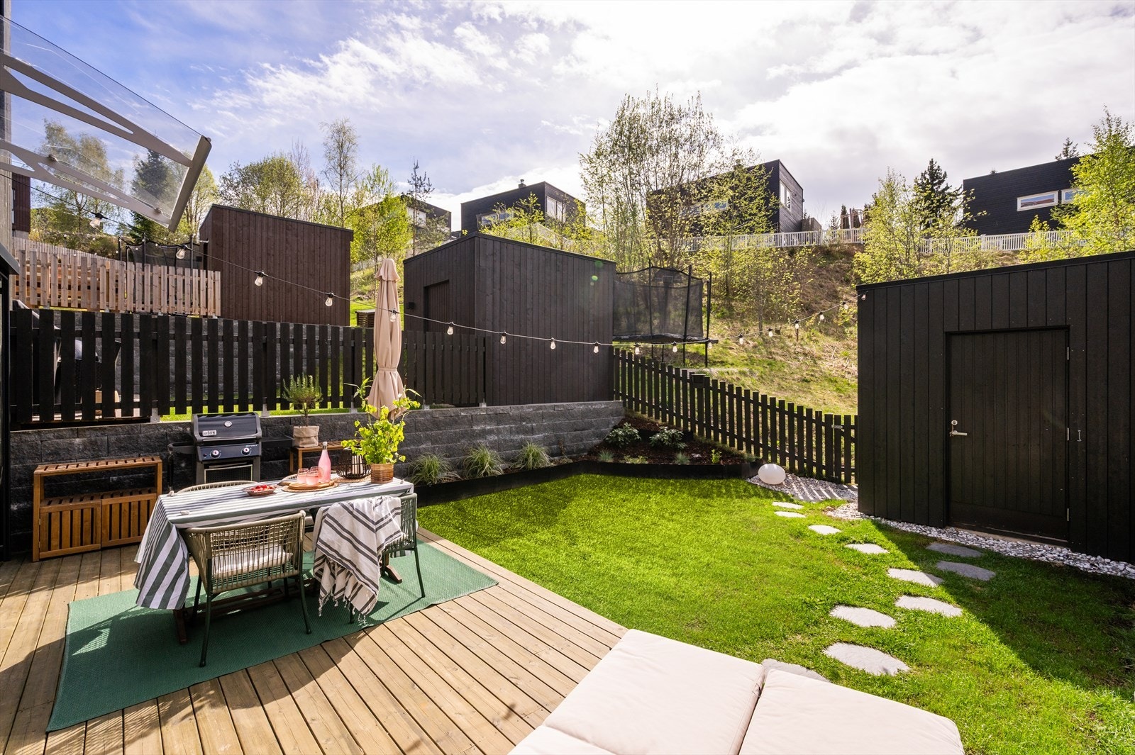 Fra stuen er det utgang til et lekkert, inngjerdet uteområde med terrasse på hele 21 kvm og tilhørende hage med nydelig beplantning. Galleribilde