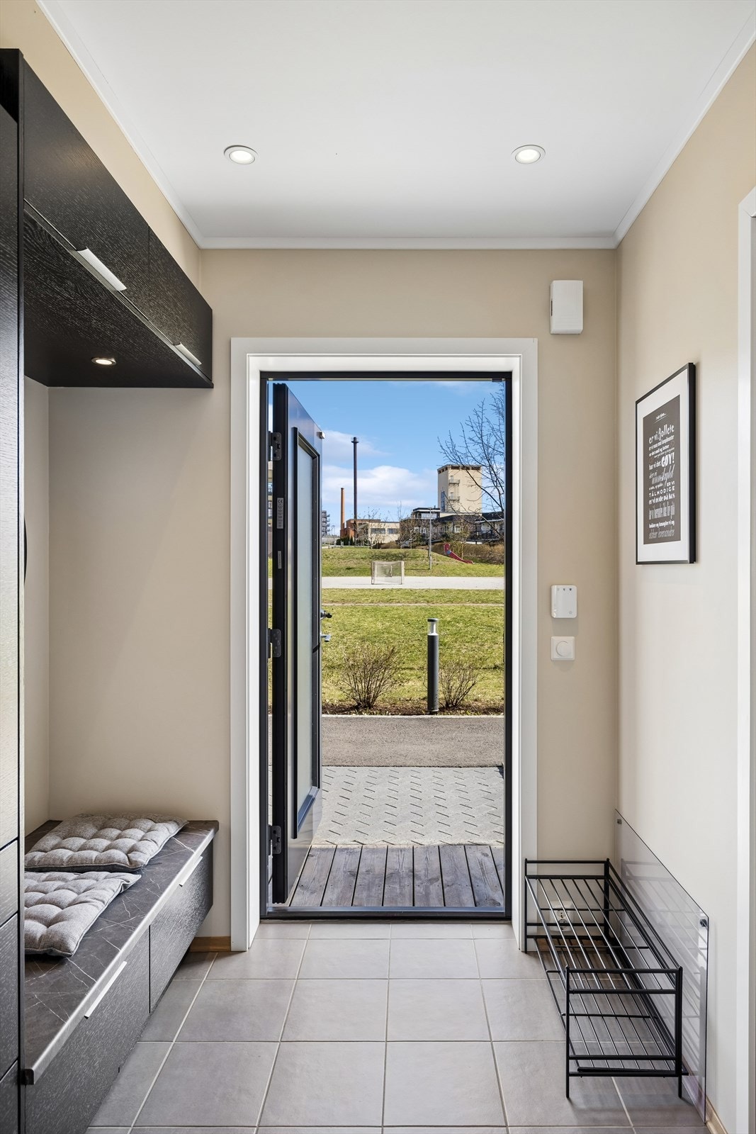 Velkommen inn! Entré med flislagt gulv og plass til garderobeløsninger. En skyvedør skiller gangen fra kjøkkenet. Galleribilde
