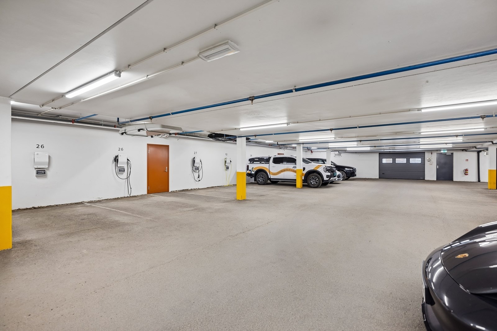 Boligen disponerer to faste parkeringsplasser, merket nr. 26, i felles parkeringskjeller. Fra parkeringen er det direkte adkomst til kjelleretasjen. Det er montert elbillader. Galleribilde