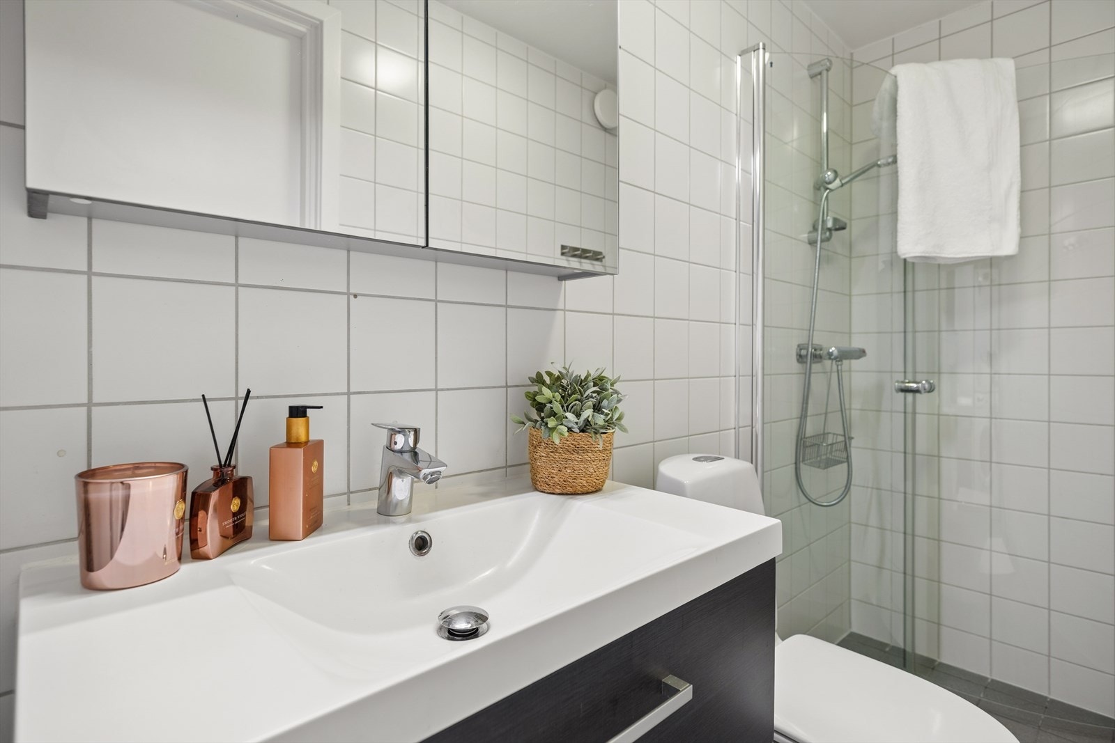 Romslig og innbydende bad i boligens tredje etasje, med en praktisk planløsning og et tidløst uttrykk. Badet er helfliset på vegger og gulv, noe som gir et stilrent preg og gjør rommet både funksjonelt og lettstelt. Galleribilde