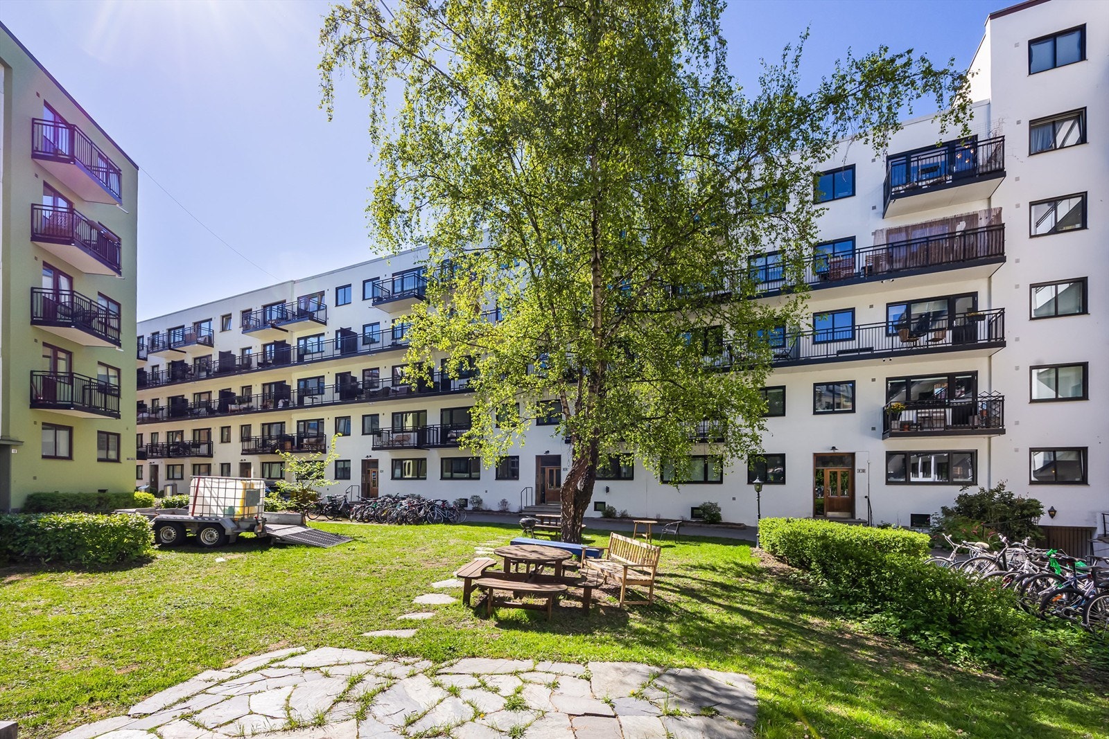 Bakgården er pent opparbeidet med plen, diverse beplantning, trær og sittegrupper. Galleribilde