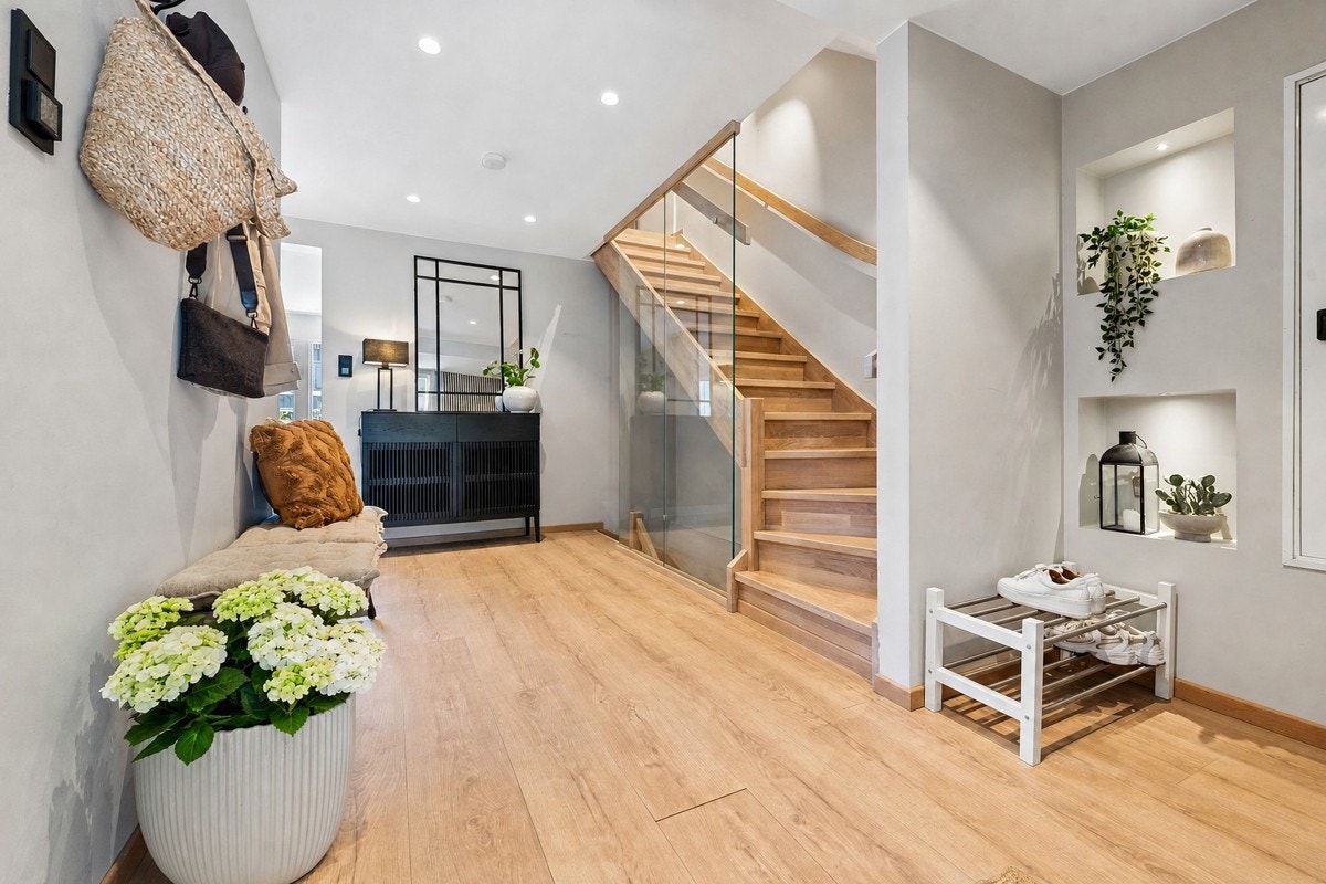 Hall/entré er bare et fantastisk rom til å ønske venner og familie velkommen. Varmefolie i gulv, downlights. Ny og moderne eiktrapp med glass fra 2023. Galleribilde