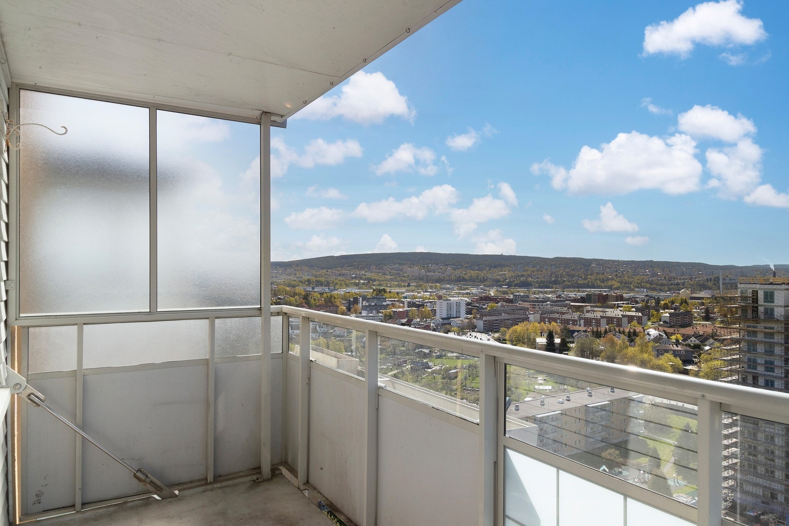 Balkongen har rekkverk i metall og glass, og et solid betongdekke. Galleribilde