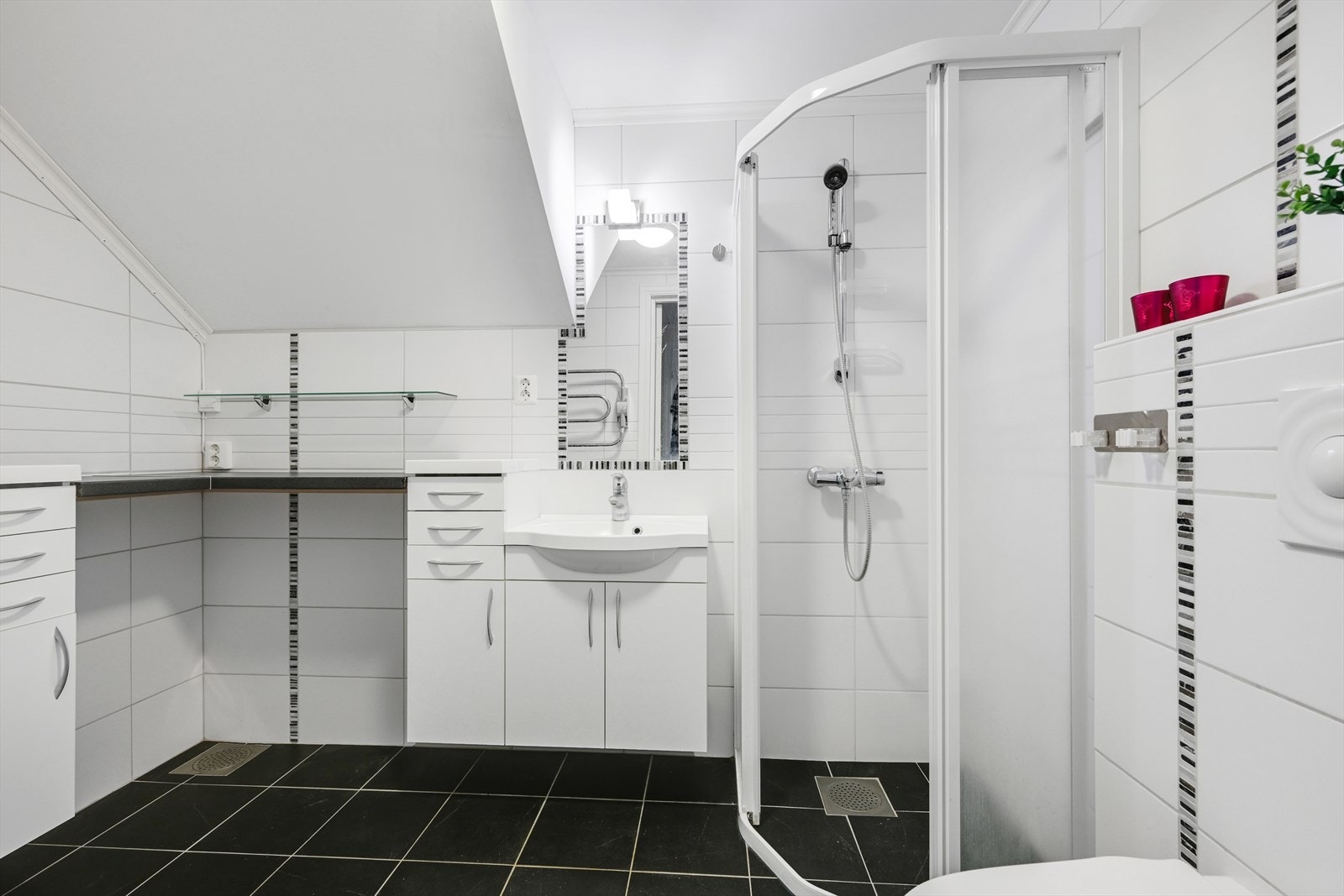 Badet i hybelen er flislagt og utstyrt med dusj, toalett, servant og opplegg for vaskemaskin. Galleribilde
