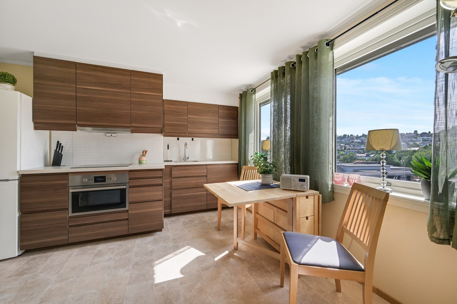 Kjøkkeninnredningen i hybelen har slette fronter og laminat benkeplate. Galleribilde