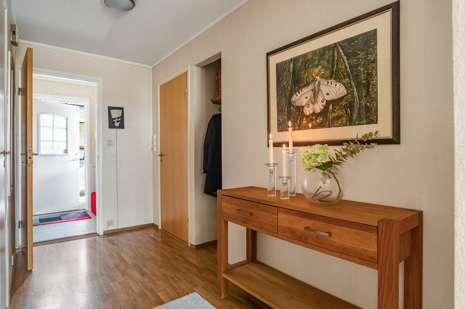 Åpen garderobeløsning med plass til oppheng av yttertøy og innbydende entrè med flislagt gulv. Galleribilde