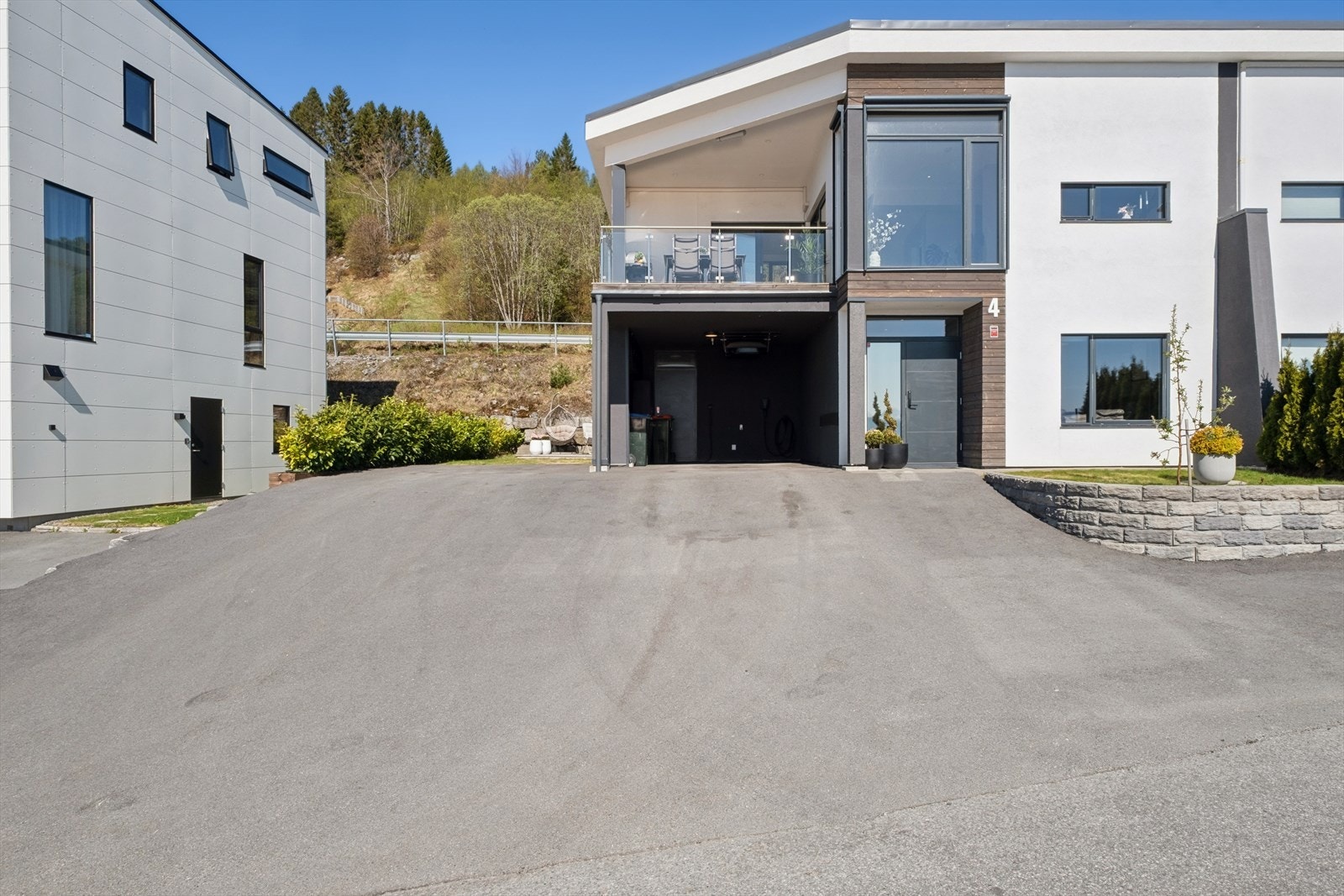 Eiendommen har en praktisk carport med installert elbillader og asfaltert gårdsplass. Galleribilde