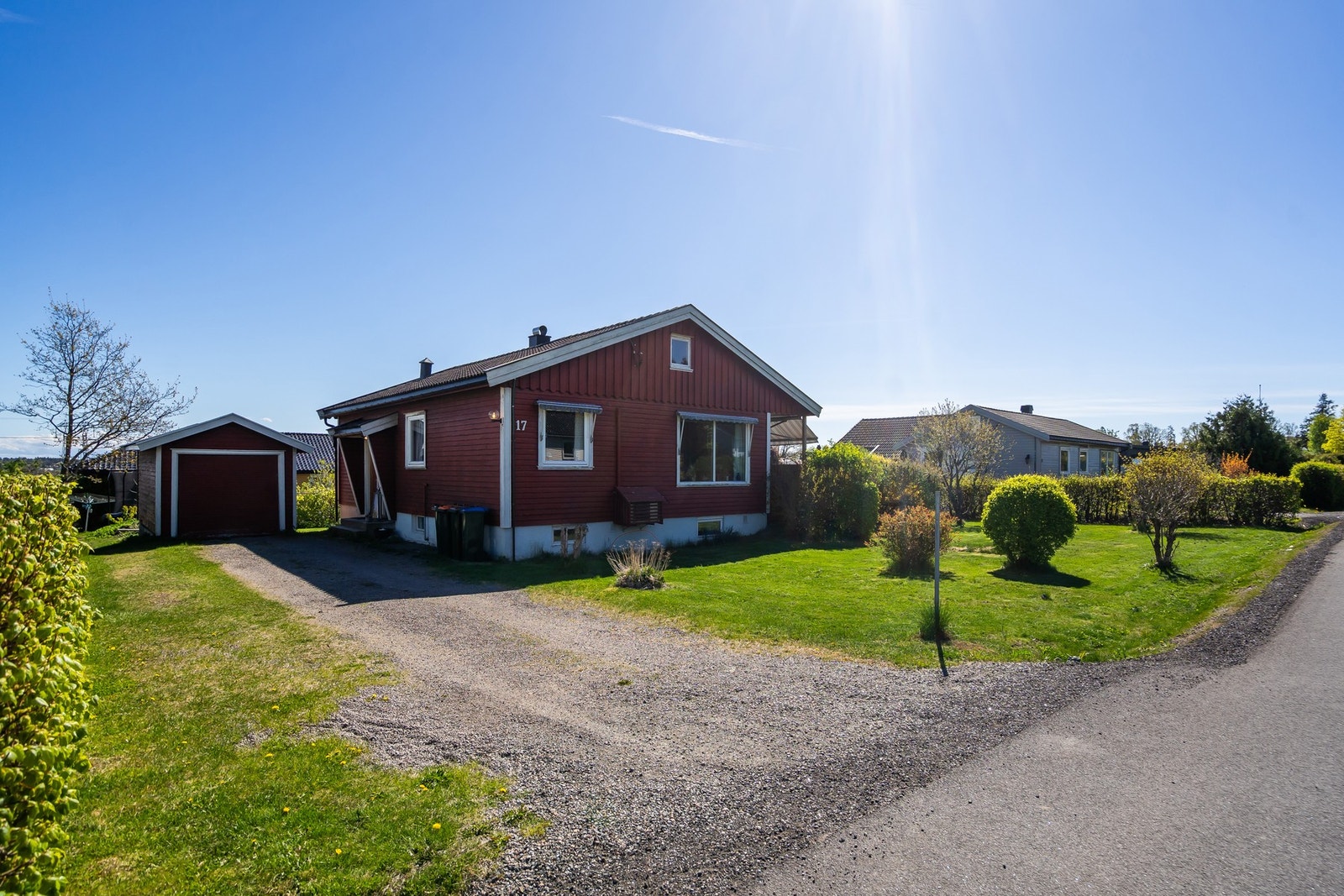 Liten garasje til bil og gruset gårdsplass Galleribilde