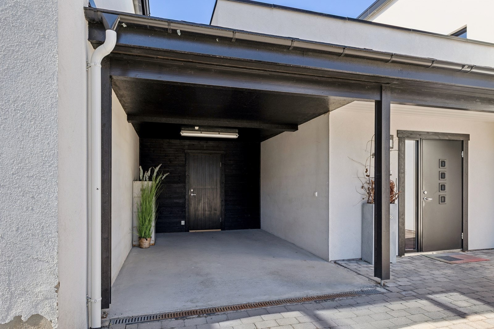 Carport og romslig bod ved inngangen til boligen. Galleribilde