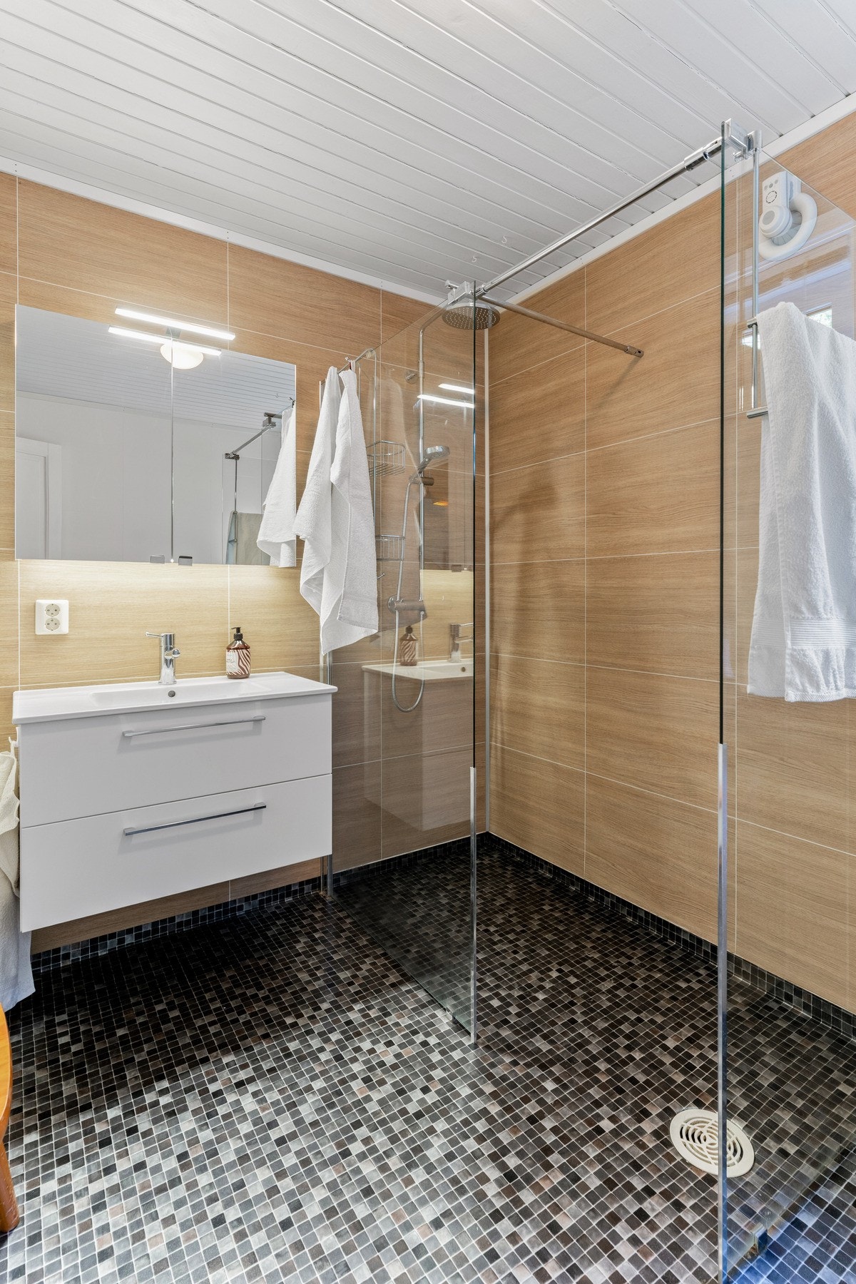 Badet er innredet med nedfelt servant, vegghengt toalett og dusjvegger/hjørne. Det gjøres oppmerksom på at sluk og avløp ikke ble byttet ut ved renoveringen i 2019. Galleribilde