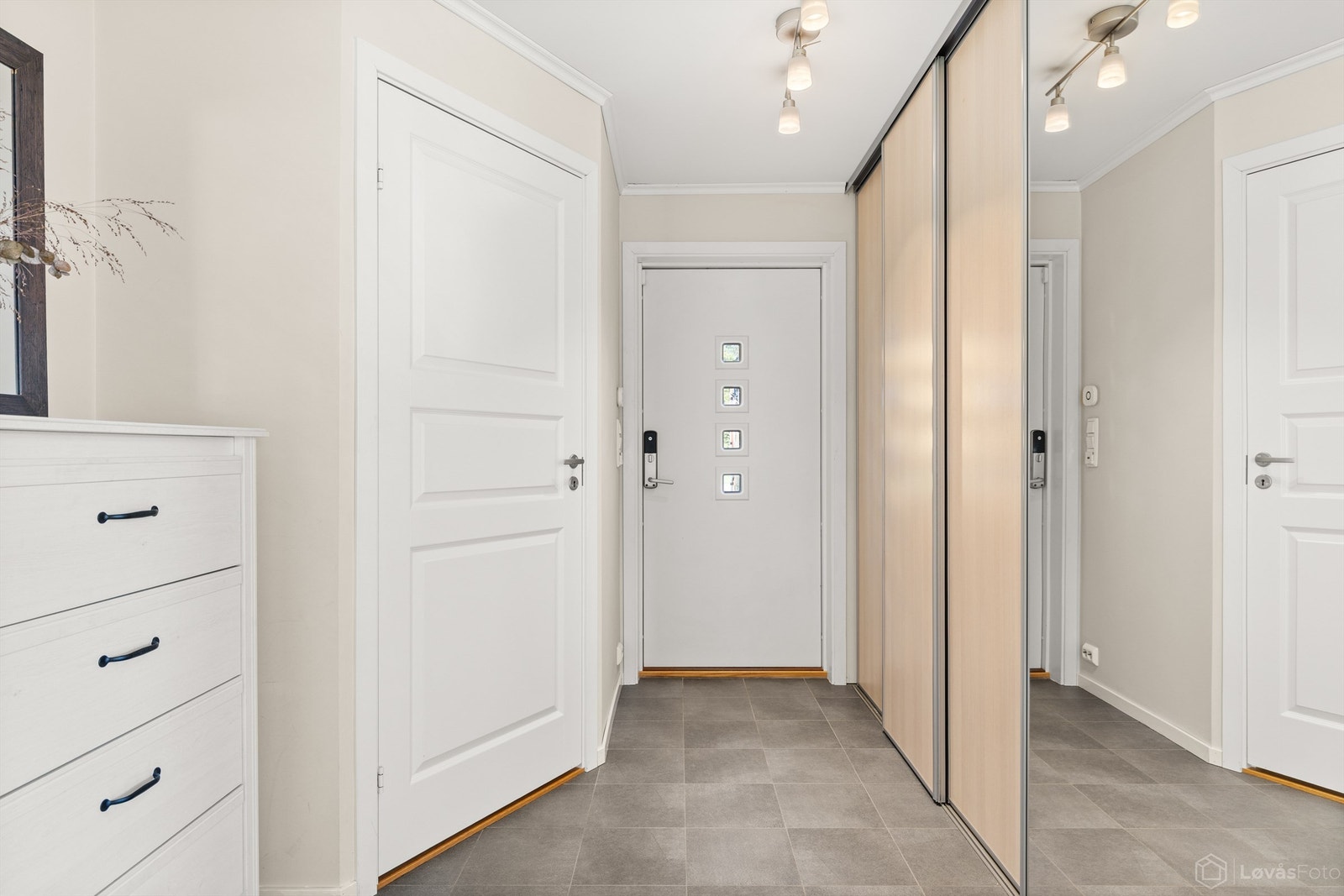 Romslig entrémed gulvfliser med gulvvarme og stor skyvedørsgarderobe med rikelig med garderobeplass Galleribilde