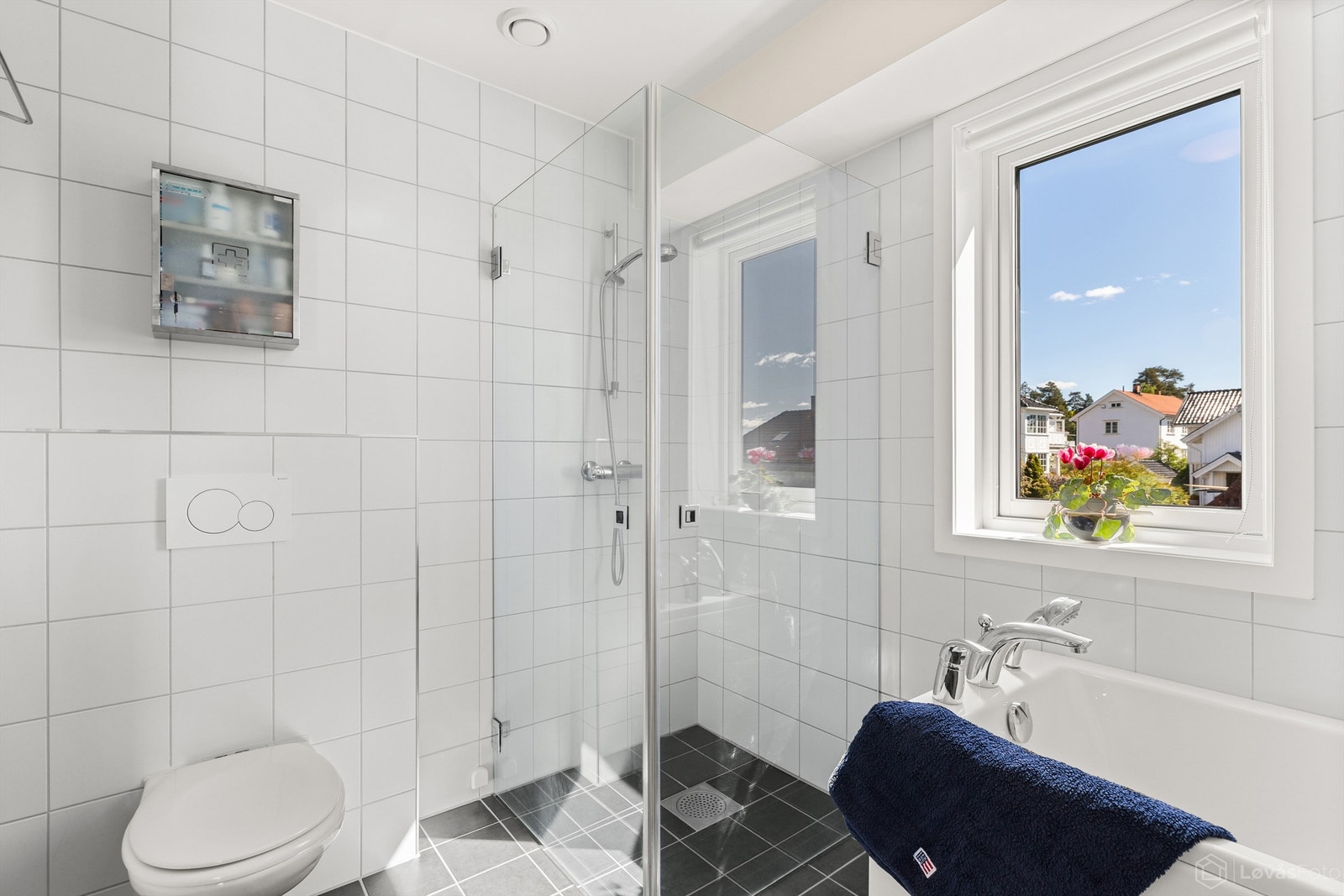 Badet er utstyrt med både badekar og et dusjhjørne med innfellbare glassdører Galleribilde