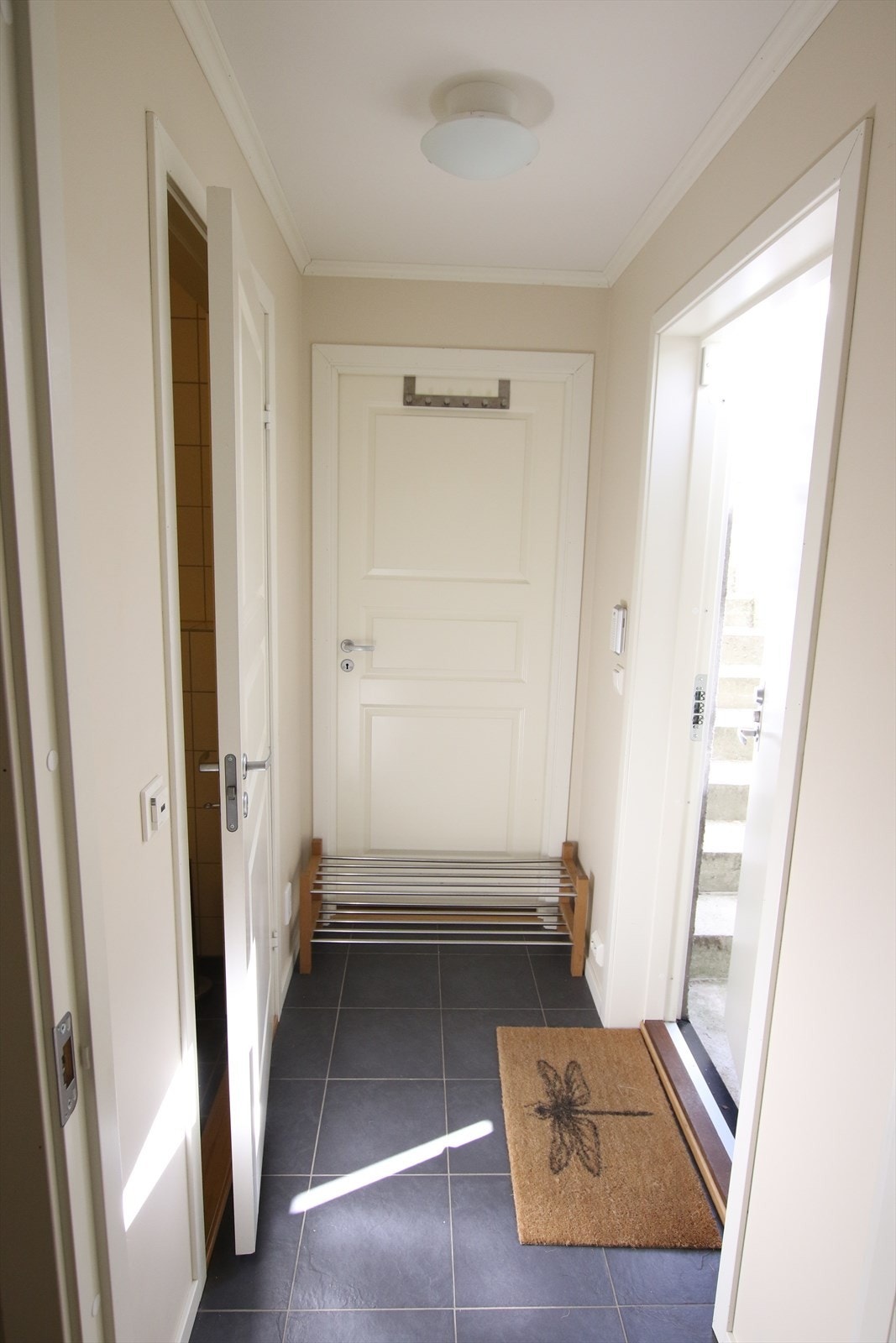 Entré/gang med gulvfliser og egen inngang via utvendig kjellertrapp. Foto: Selgers private bilde Galleribilde