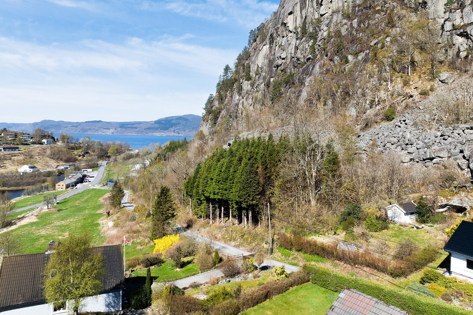 Pga gammel skyddleig er grensene noe fiktive, men fra gammelt av er det gjerder og busker som naturlig rammer inn tomtene på begge sider av veien. Teig til høyre i bilde med liten hvit bod tilhører eiendommen og hagen rundt. Galleribilde
