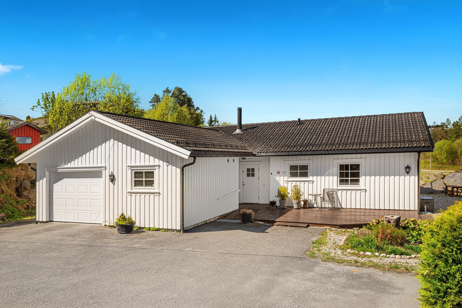 Pent opparbeidet tomt med gruset adkomstvei og asfaltert tun. Galleribilde