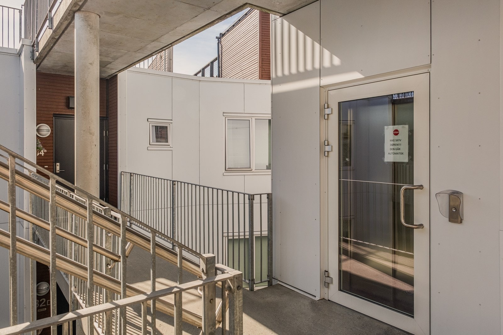 Tak over svalgang utenfor leiligheten. Heisen tar deg en etasje opp til takterrasse eller til kjeller med bod og parkeringsplass. Galleribilde