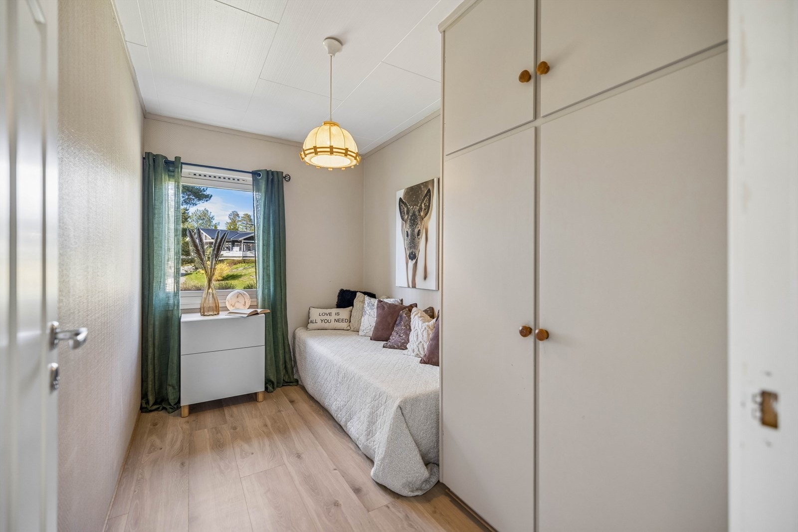 Soverom med laminat på gulvet og plassbygde skap. Galleribilde