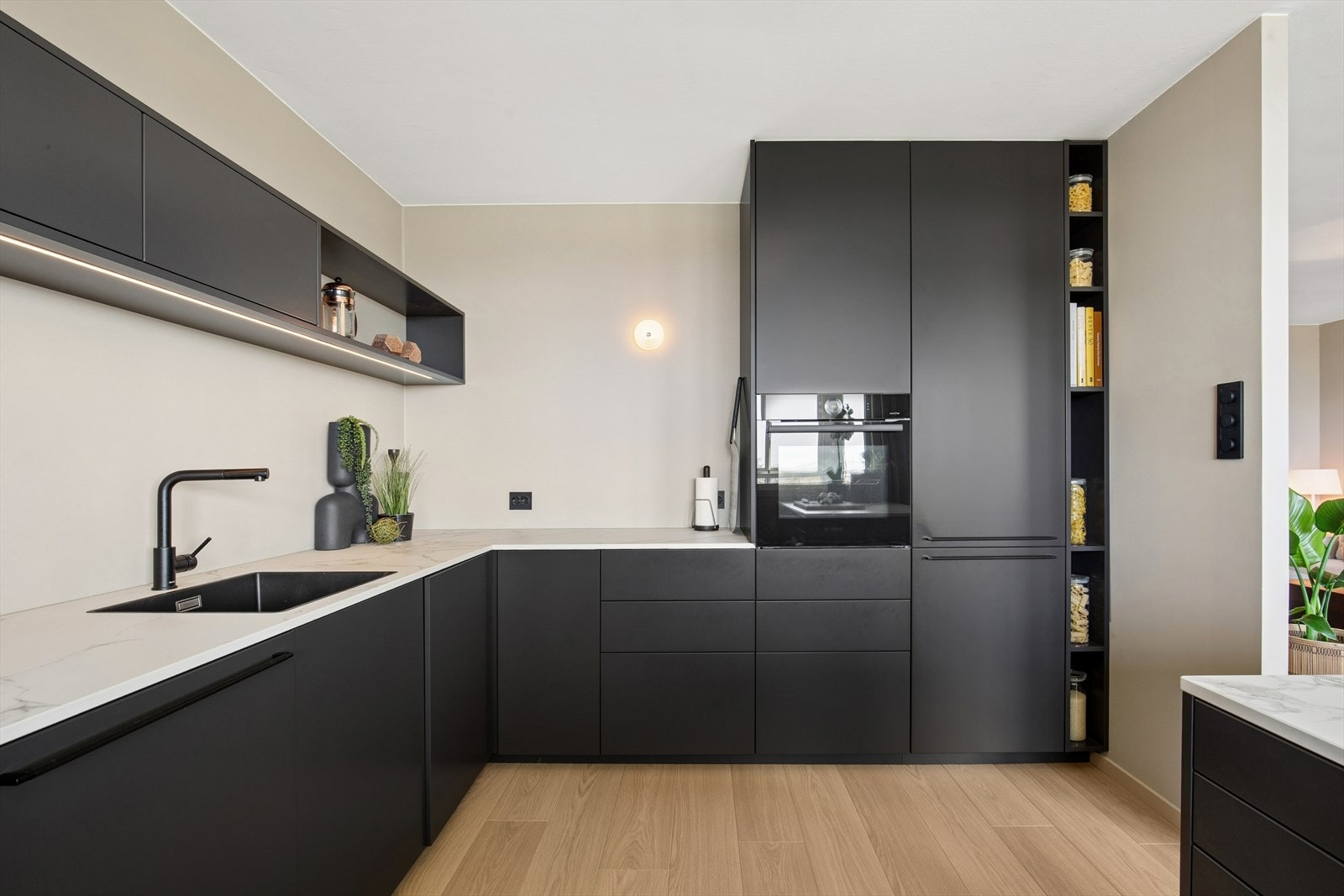 Lekkert kjøkken fra 2023 med DEKTON benkeplate og plassbygde løsninger med integrerte hvitevarer. Galleribilde
