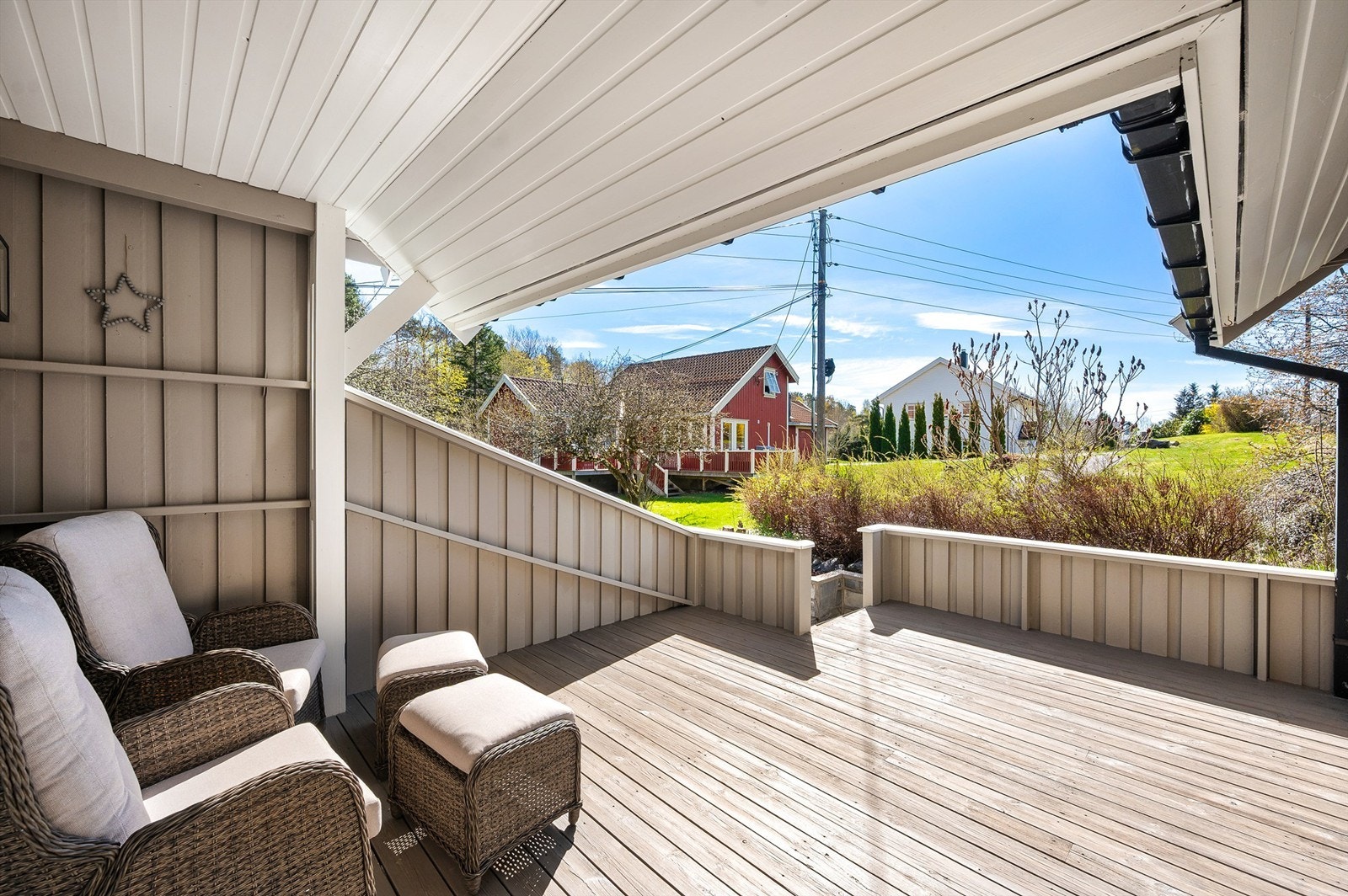Lun og fin terrasse med delvis overbygg og utsyn utover det omkringliggende landskapet Galleribilde
