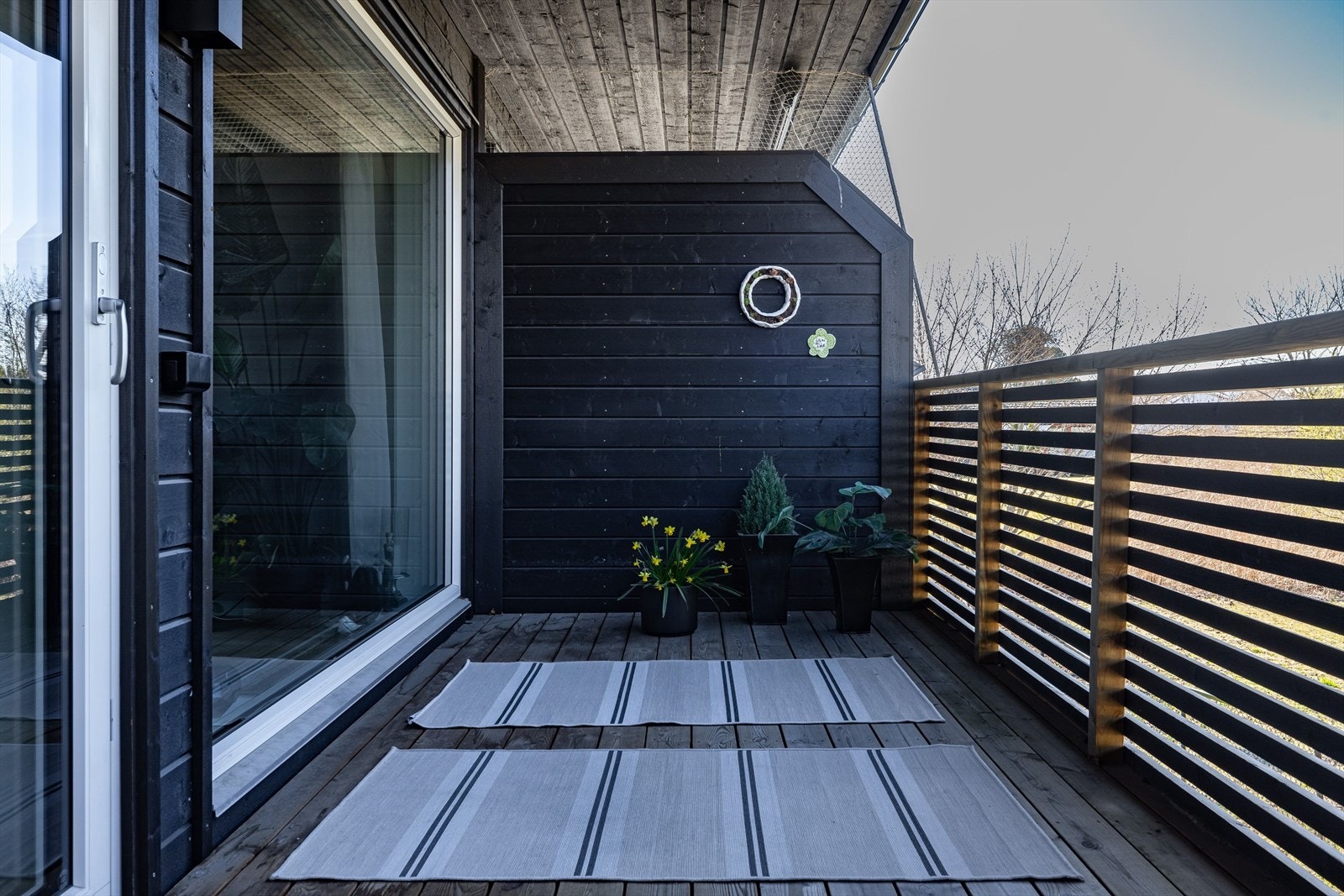 Balkongen er overbygget og har terrassebord på gulv. Det er også montert utebelysning og stikkontakt. Galleribilde