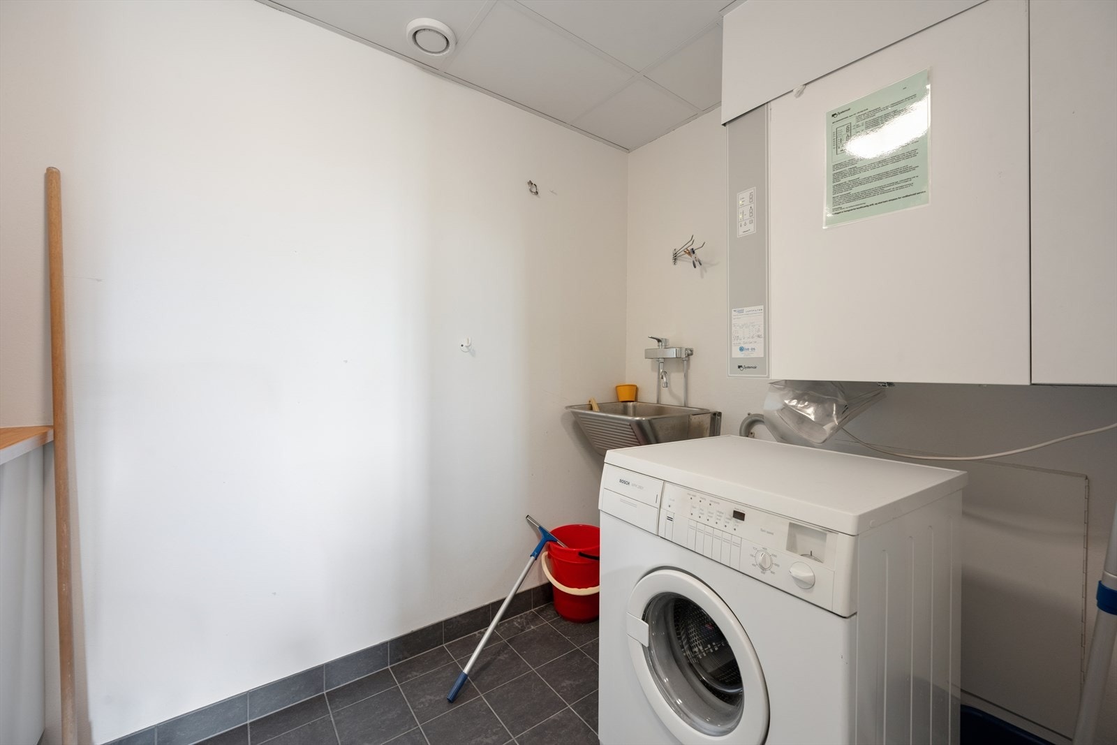 Leiligheten har også et eget vaskerom utstyrt med utslagsvask, motor for det balanserte ventilasjonsanlegget og opplegg for vaskemaskin. Galleribilde