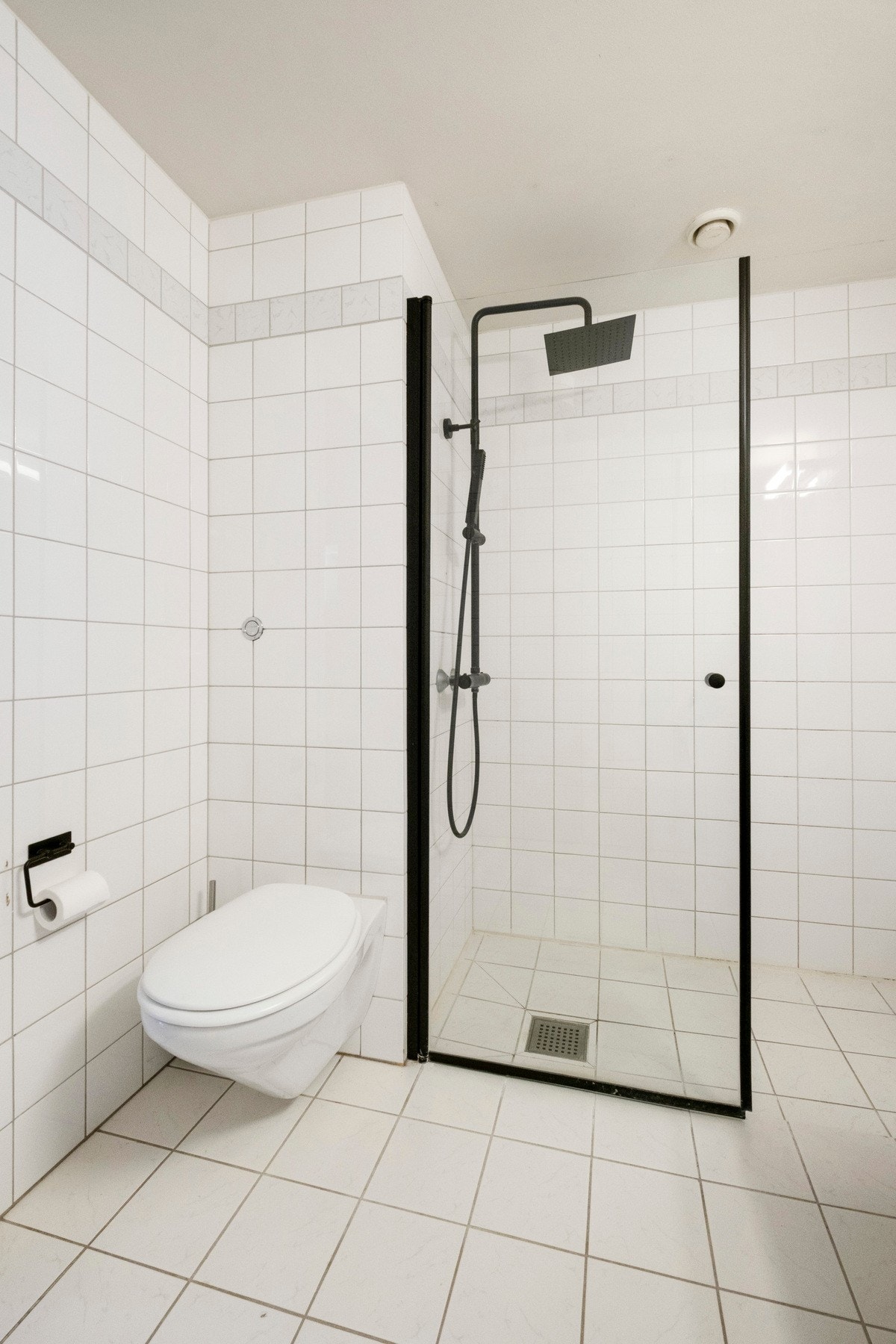 Badet er utstyrt med heldekkende servant på underskap med folierte fronter, innmurt speil og veggmontert toalett med innebygget sisterne. Dusjhjørne med svingbar glassdør og rainfalldusj. Galleribilde