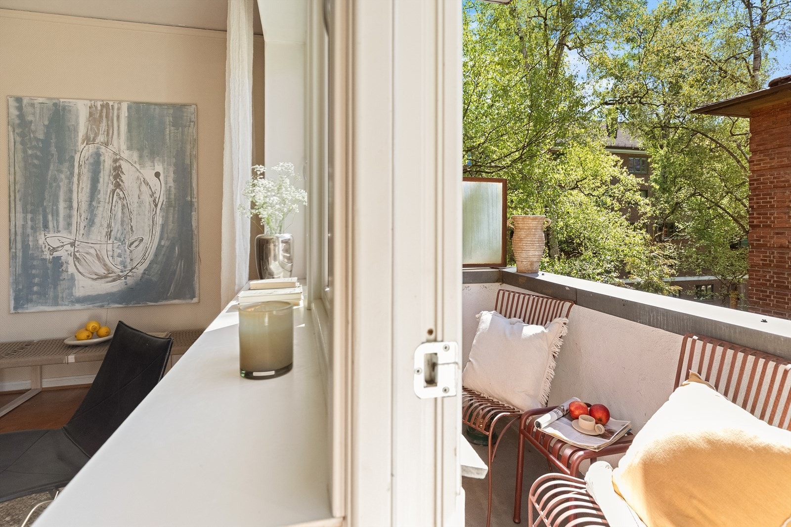 Balkongen har plass til en sittegruppe og vender ut mot et rolig og grønt område. Galleribilde