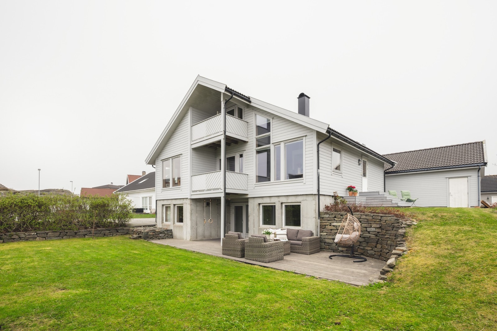 Pent opparbeidet hage med plen, terrasser og beplantning. Galleribilde