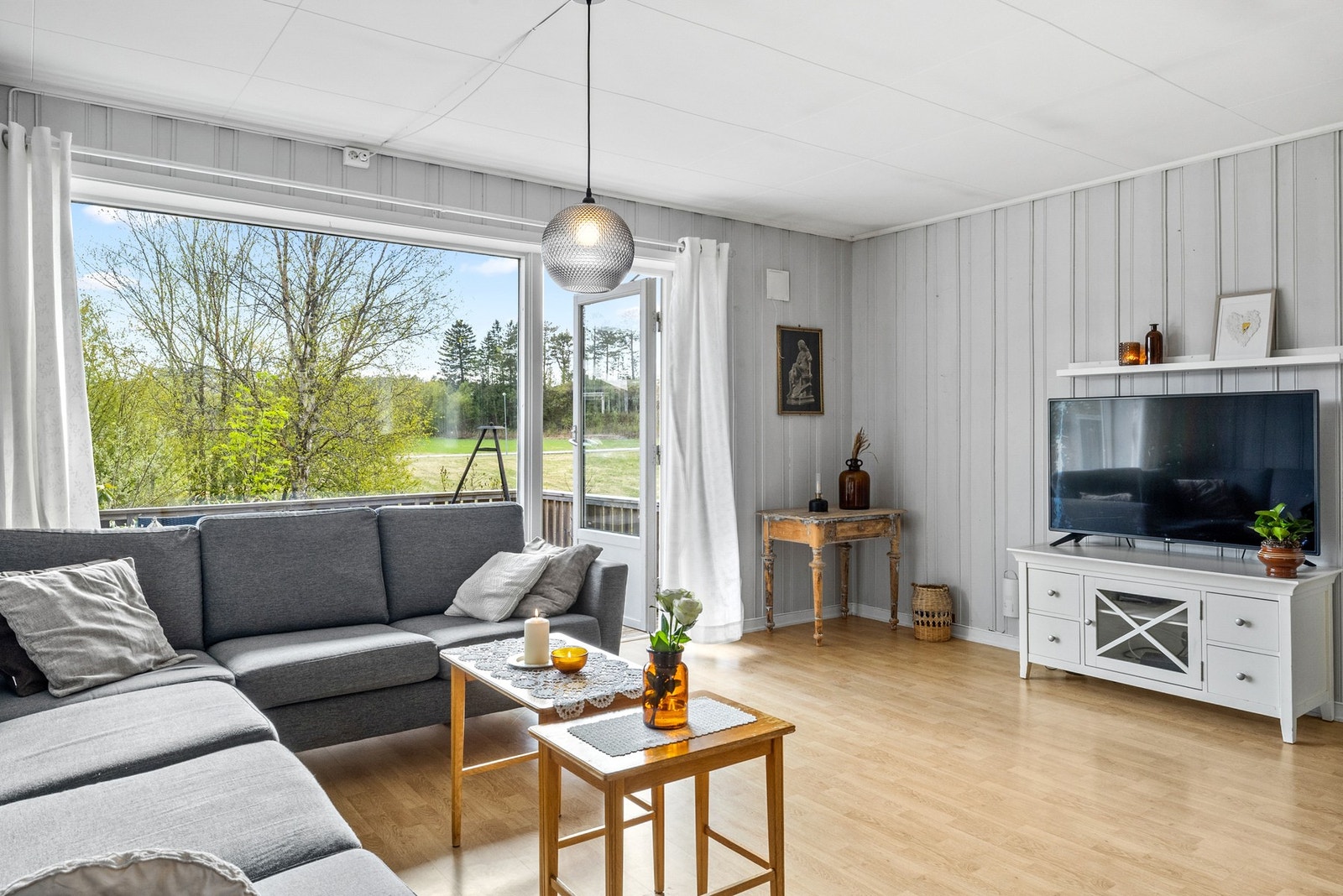 Stuen leder ut til en skjermet og trivelig veranda i rolige og landlige omgivelser Galleribilde