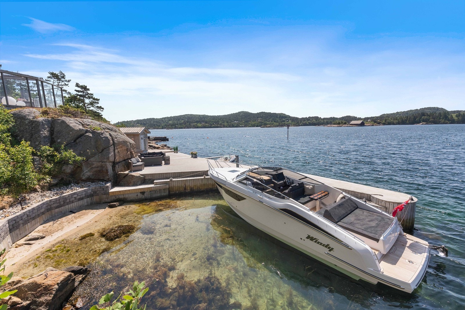 Denne delen har en solid betongbrygge med sjøbu og molo som skjermer for vær og vind. Galleribilde