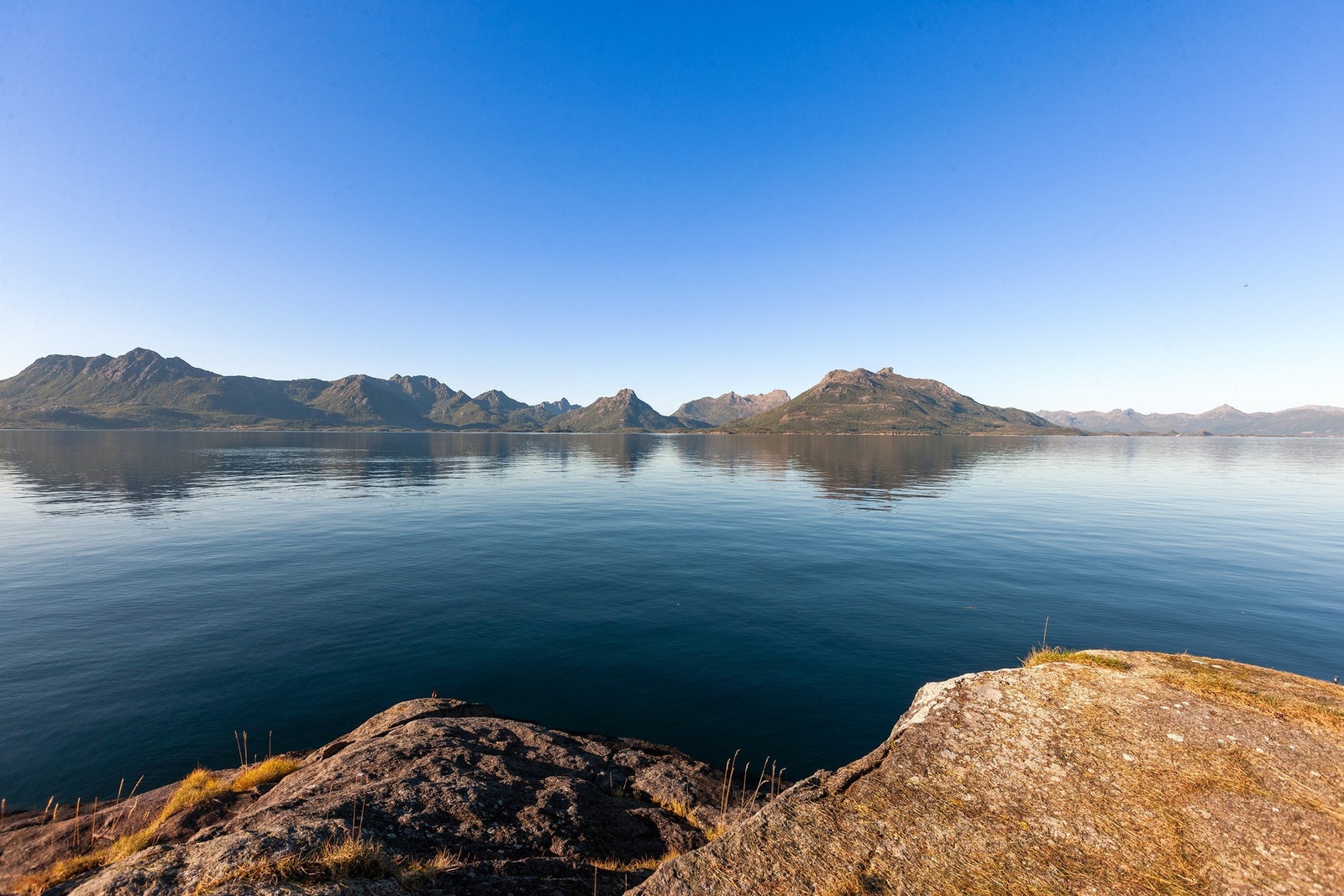 Utsikt mot fjell som Soumtinden og Beitinden. Eiendommen ligger idyllisk til på østsiden av Eidsfjorden, omgitt av vakre naturomgivelser og rolig fjordlandskap. Galleribilde