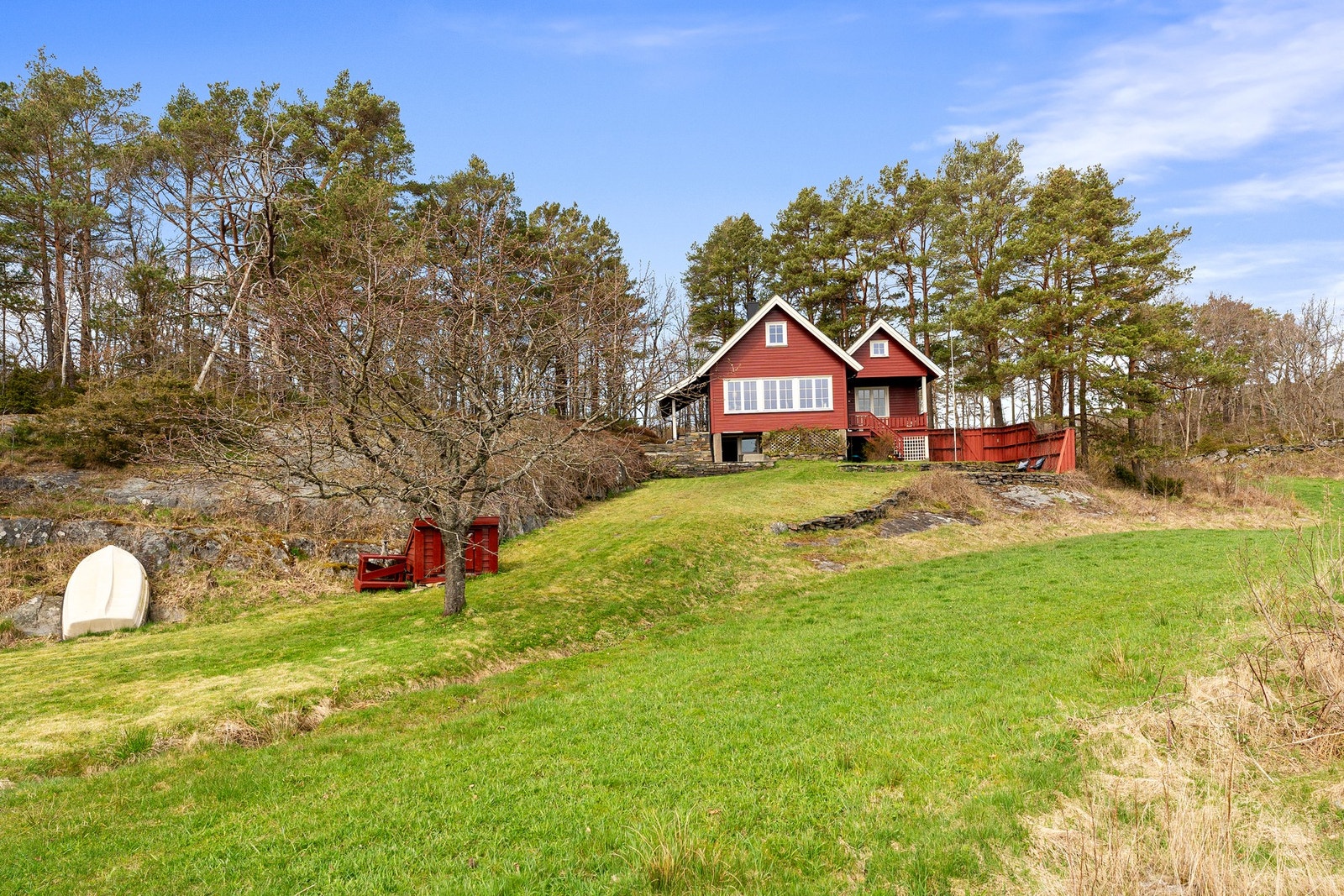 Hytten ligger i naturskjønne omgivelser på en liten høyde, med solrike uteplasser og gressplen ned til sjøen. Galleribilde
