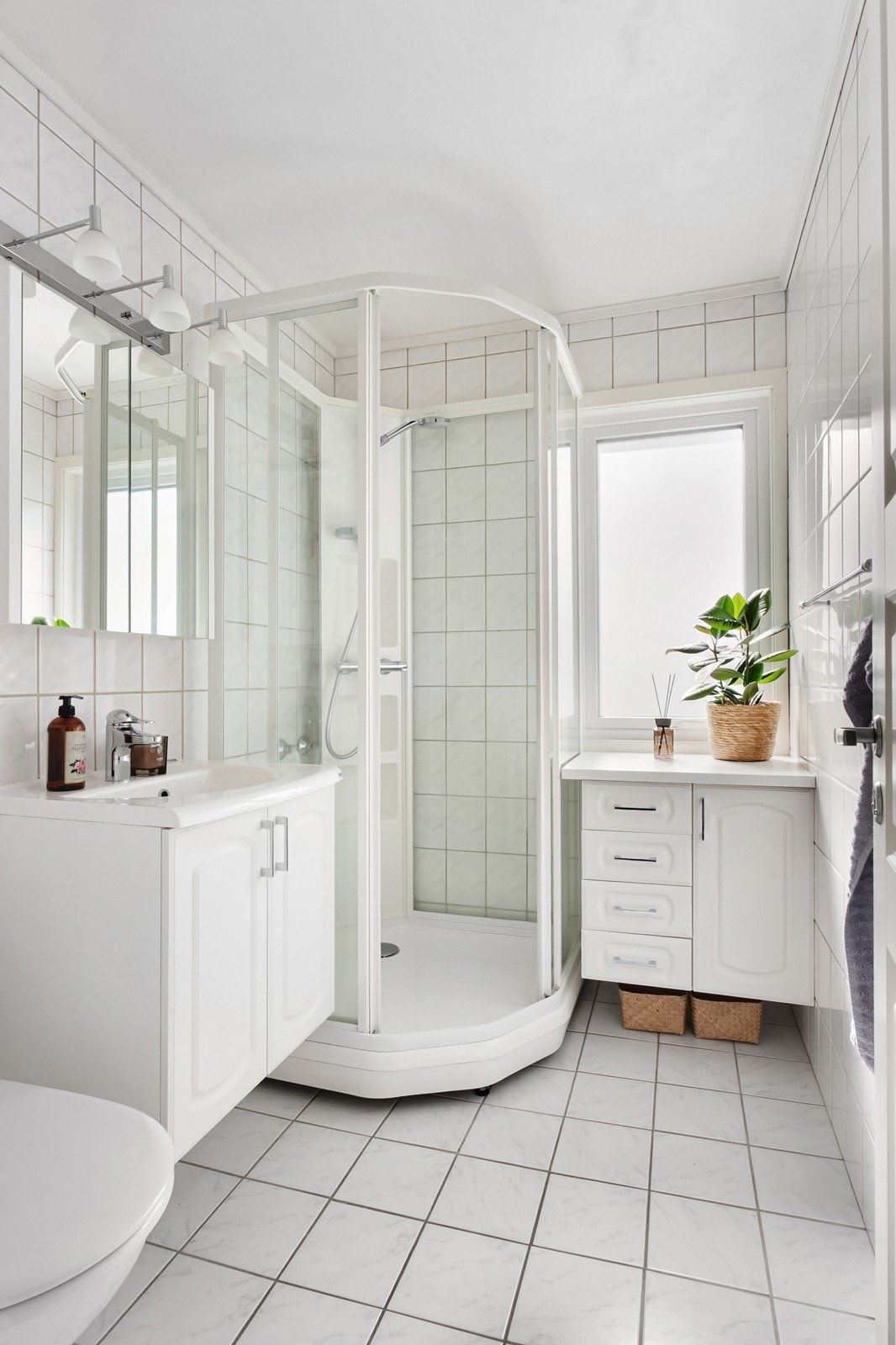 Badet er innbydende med lyse, flislagte overflater og hvit innredning. Galleribilde