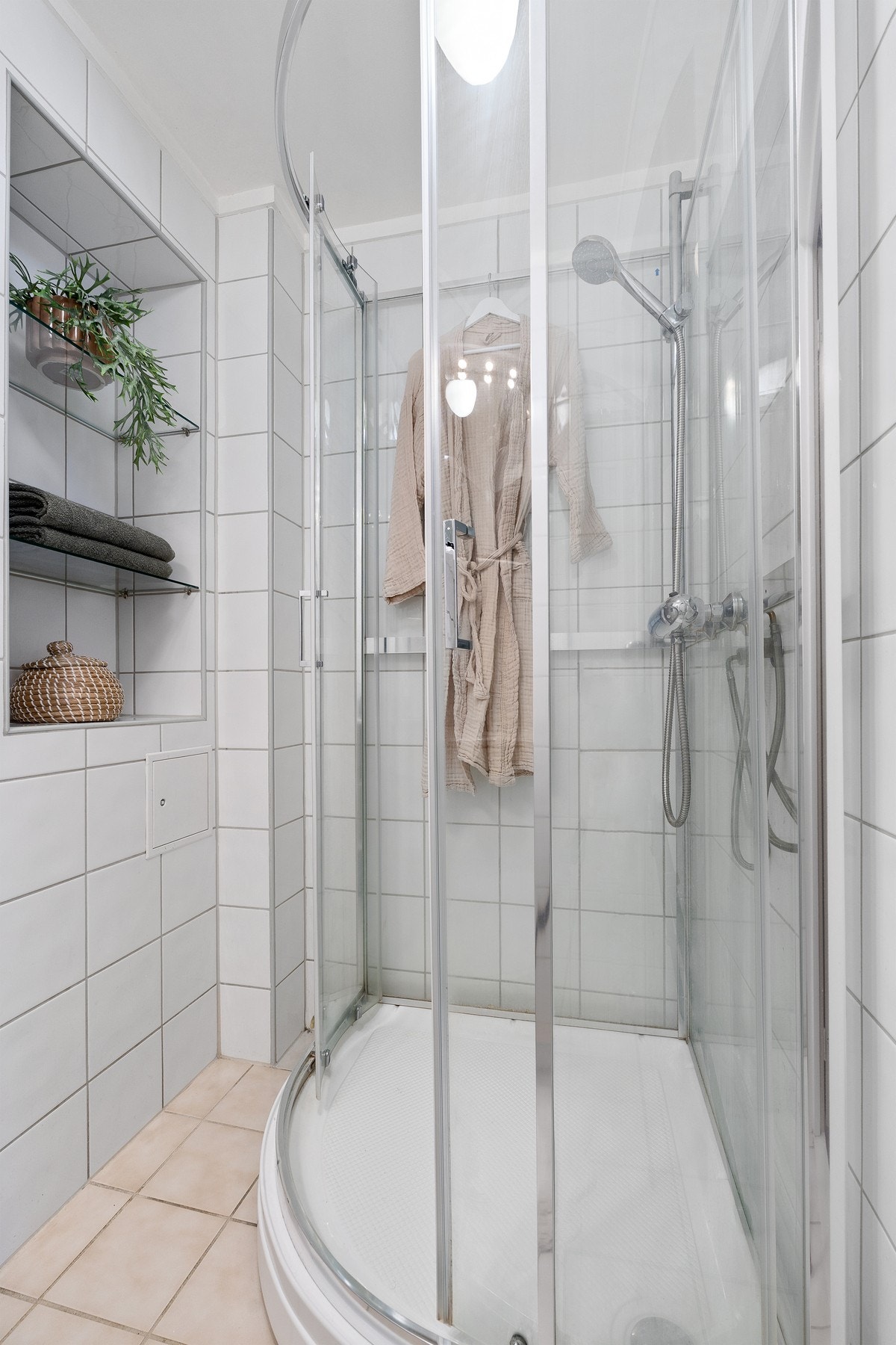 Badet er innredet med dusjkabinett, WC, Servant med underskap og speil. Galleribilde