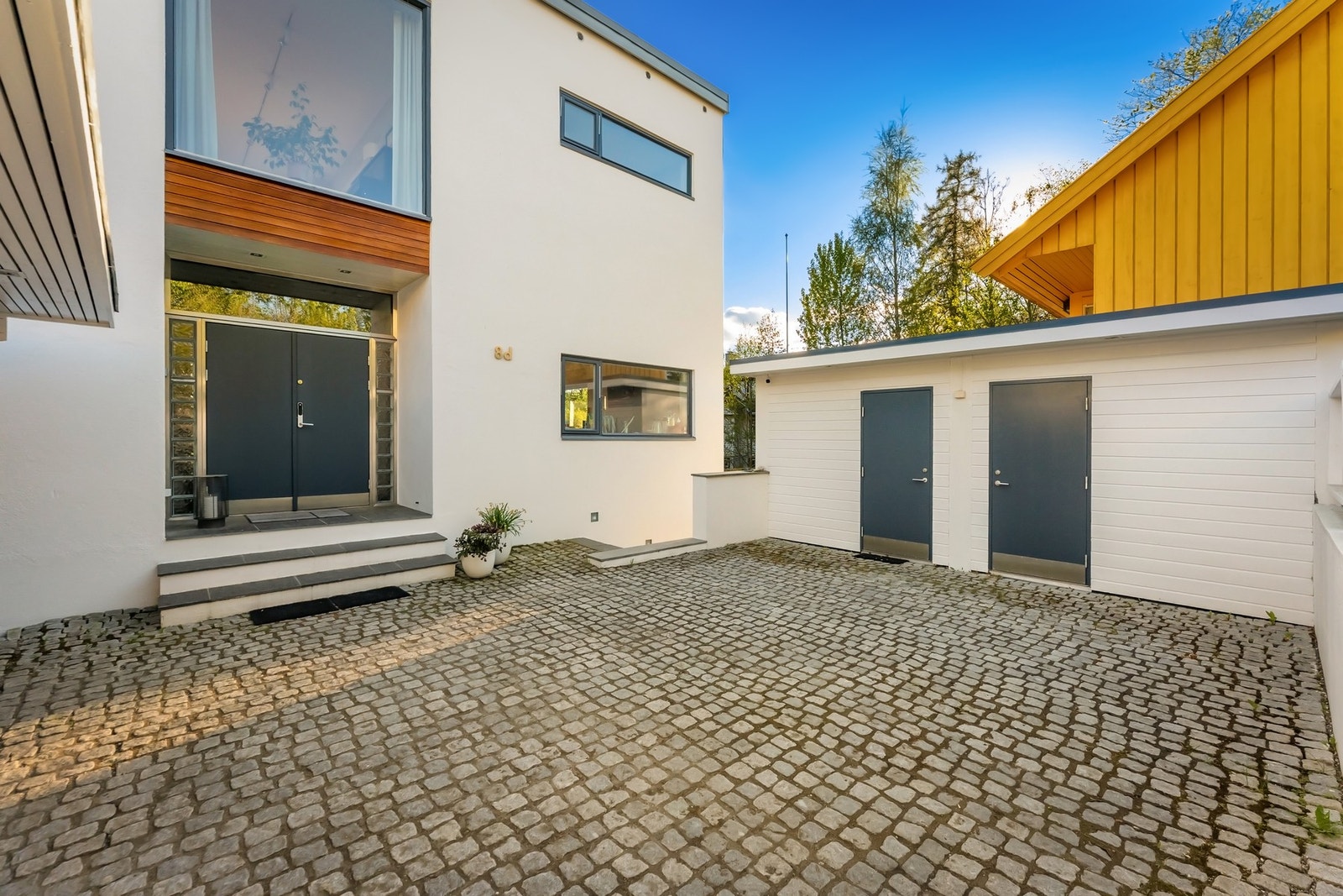 Romslig gårdsplass med to praktiske redskapsboder. Galleribilde