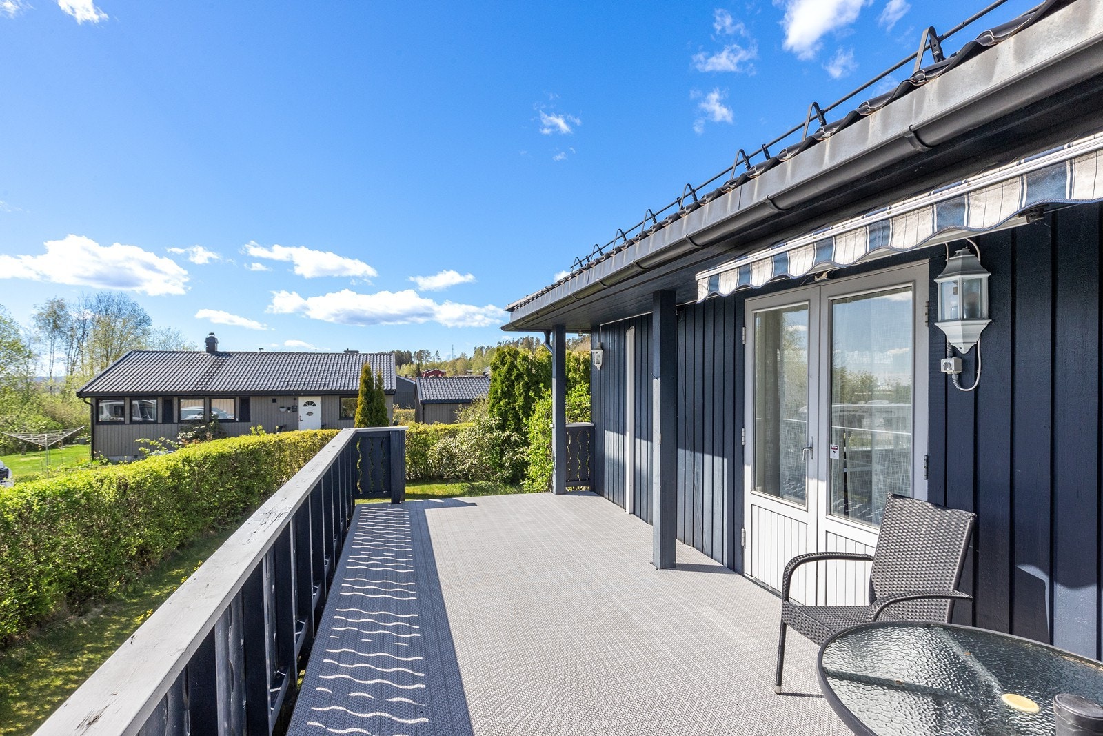 Verandaen på 21 m² har trykkimpregnerte gulvbord og malt trevirke på rekkverket. Galleribilde