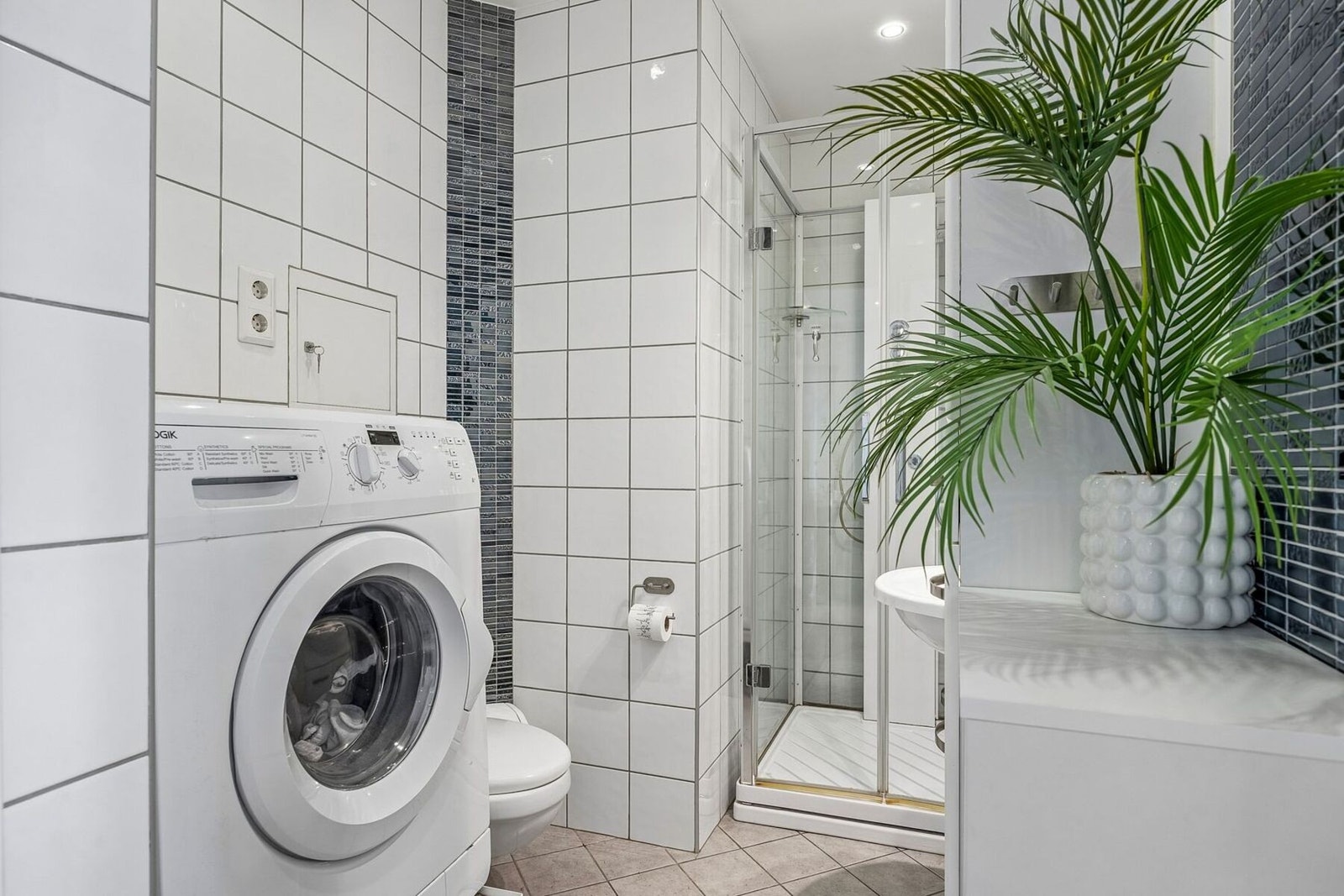 Badet er tilrettelagt med praktisk opplegg for vaskemaskin. Galleribilde