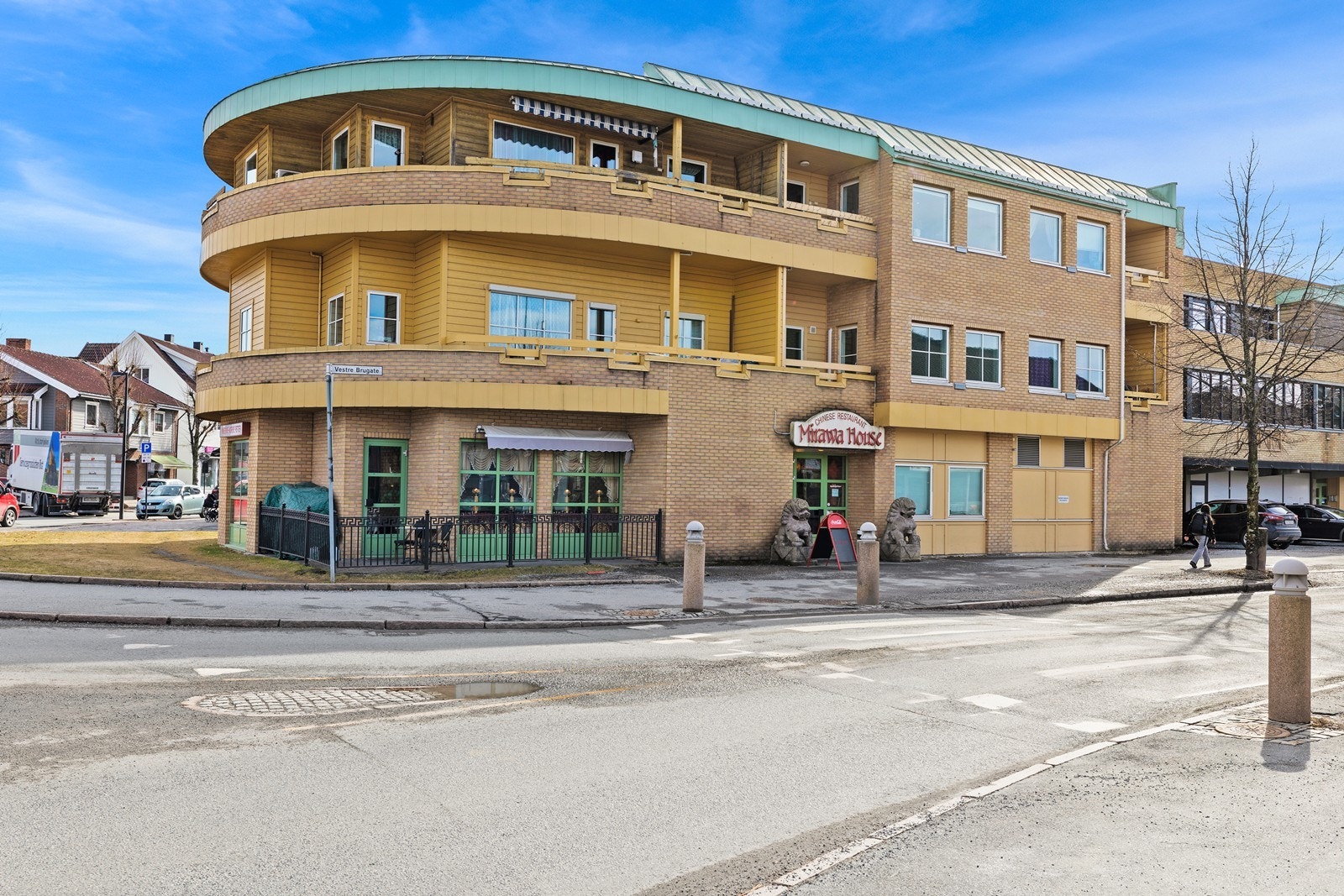 Byggets fasade består av gul tegl og horisontalt trepanel. Galleribilde