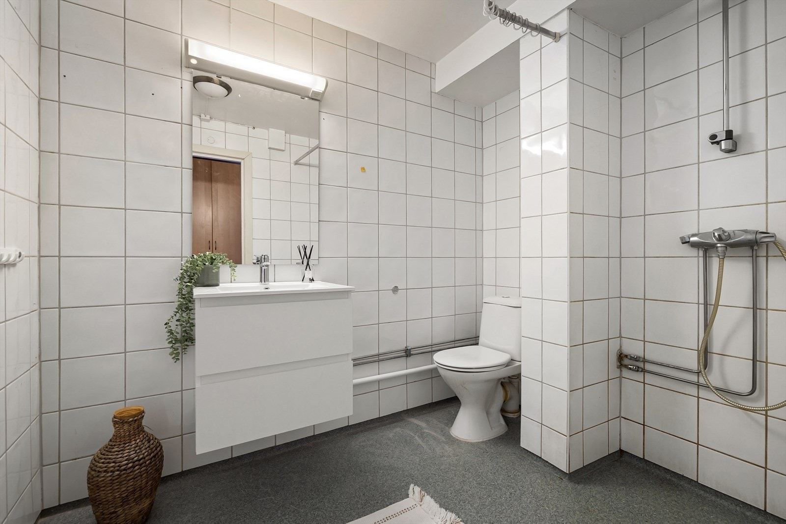 Badet har flislagte vegger og belegg på gulvet med elektriske varmekabler. Galleribilde