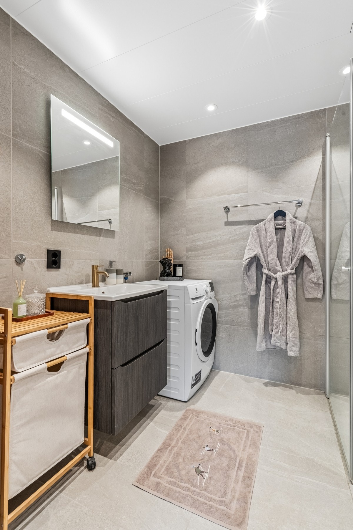 Badet har opplegg for vaskemaskin og god plass til oppbevaringsløsninger. Galleribilde