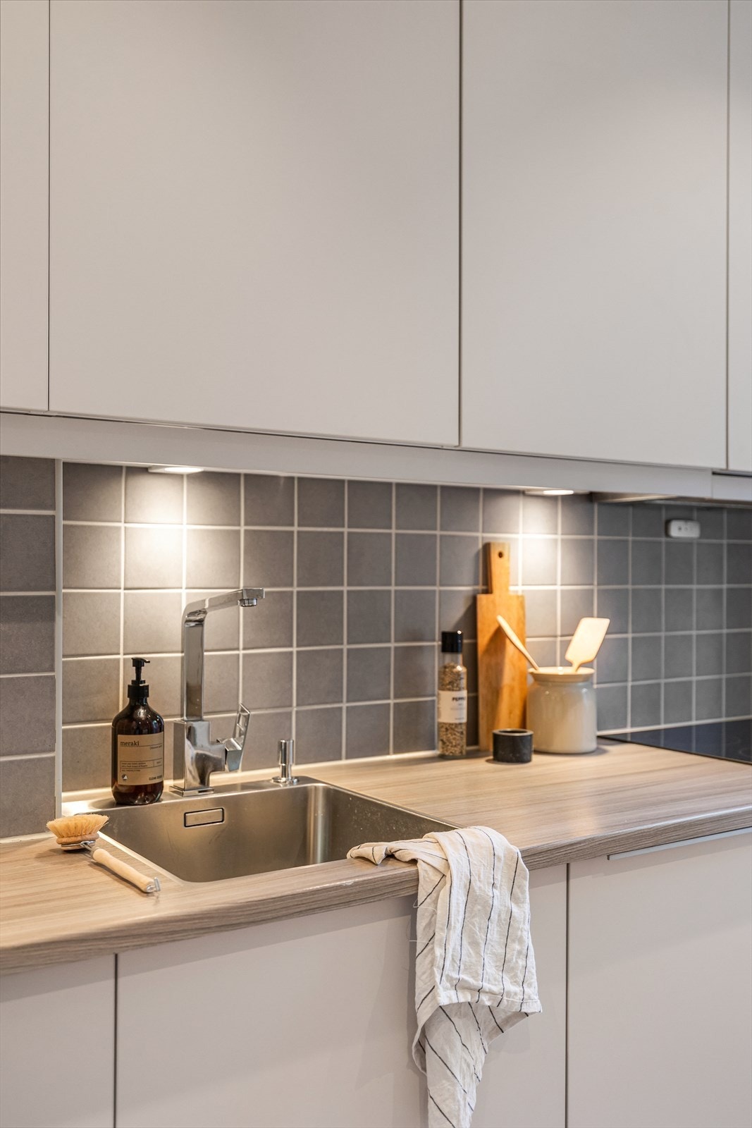 Innredningen har slette fronter og laminat benkeplate, med planlimt oppvaskkum i rustfritt stål og ettgreps armatur. Galleribilde