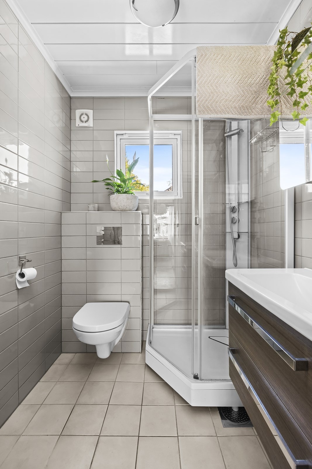 Badet inneholder servant i innredning, vegghengt wc og dusjkabinett Galleribilde