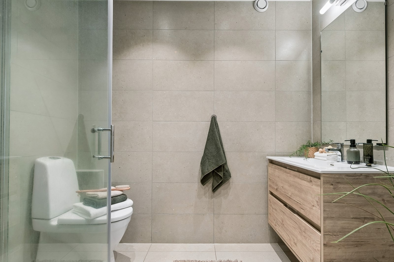 Det delikate badet er utstyrt med dusjhjørne med glassdører, gulvstående toalett og opplegg for vaskemaskin. Badet ble pusset opp i 2022 og har flislagte overflater og elektriske varmekabler i gulvet. Galleribilde