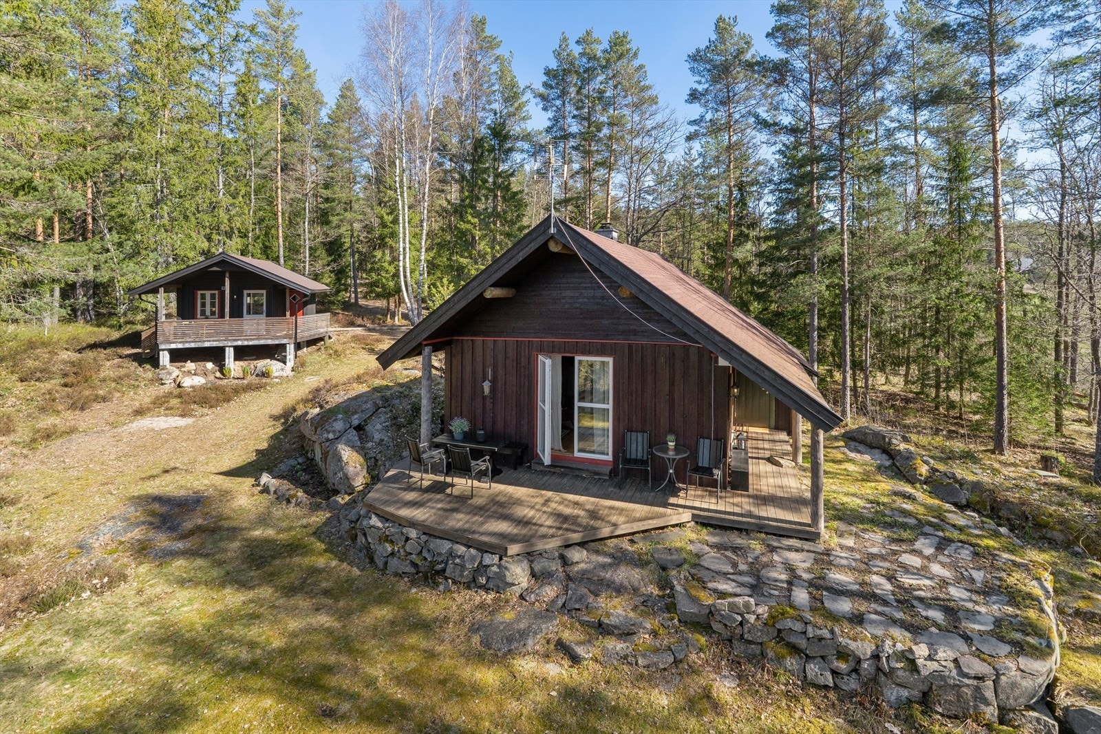 Eiendommen består av en innholdsrik hytte og et frittstående anneks, plassert på en kupert naturtomt. Galleribilde