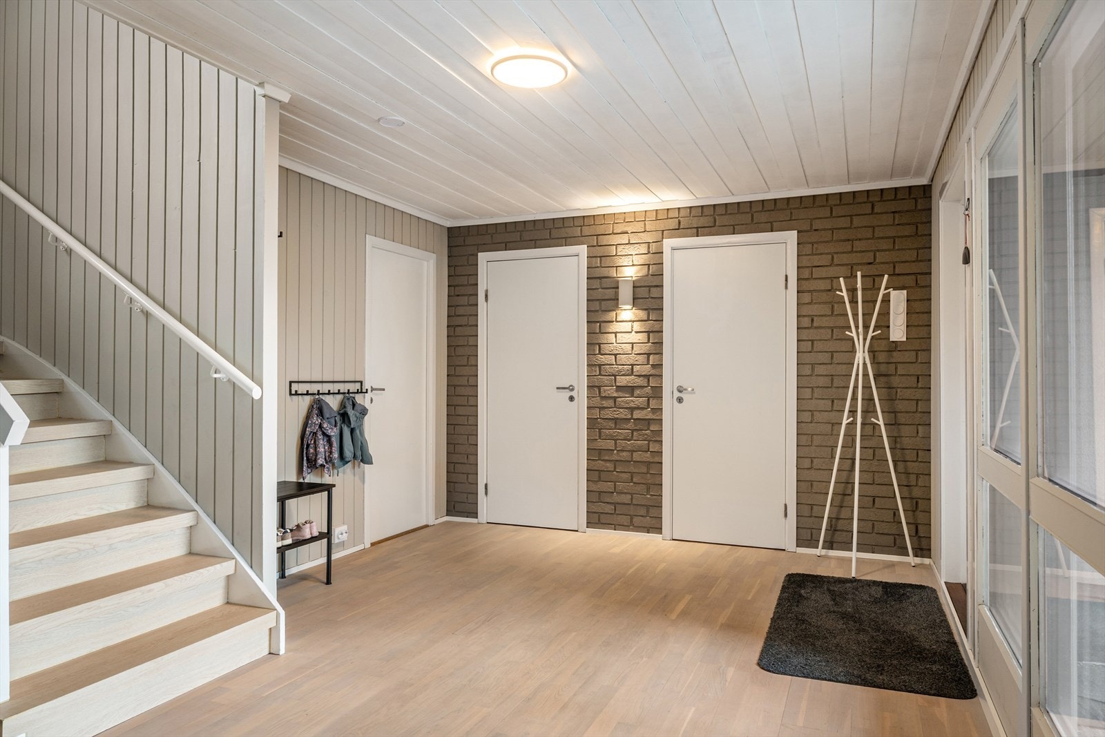 Boligens inngangsparti ligger i underetasjen. Man ønskes velkommen inn i en stor og lys entré/gang hvor man har god plass til å møblere med garderobe hvor man kan henge fra seg yttertøy og sko. Galleribilde