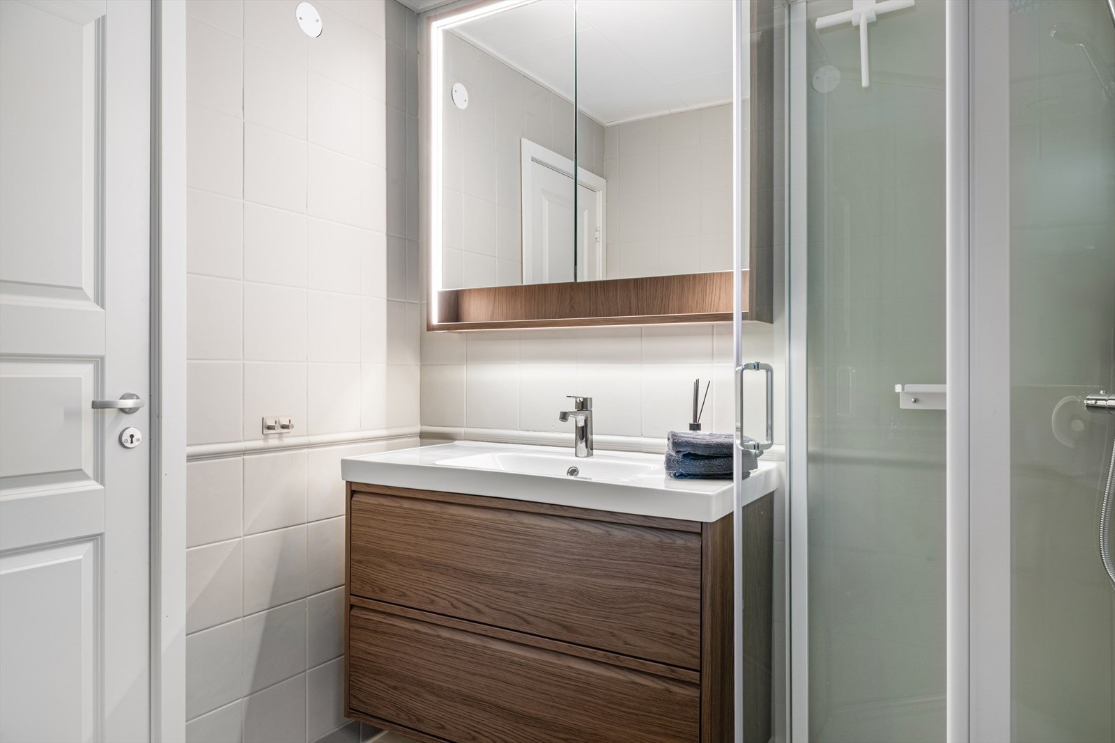 Badet er ellers utstyrt med dusjkabinett, toalett og baderomsinnredning med god lagringsplass og nedfelt servant. Naturlig ventilering via ventil i tak og luftespalte i dør (se punkt "ferdigattest"). Galleribilde