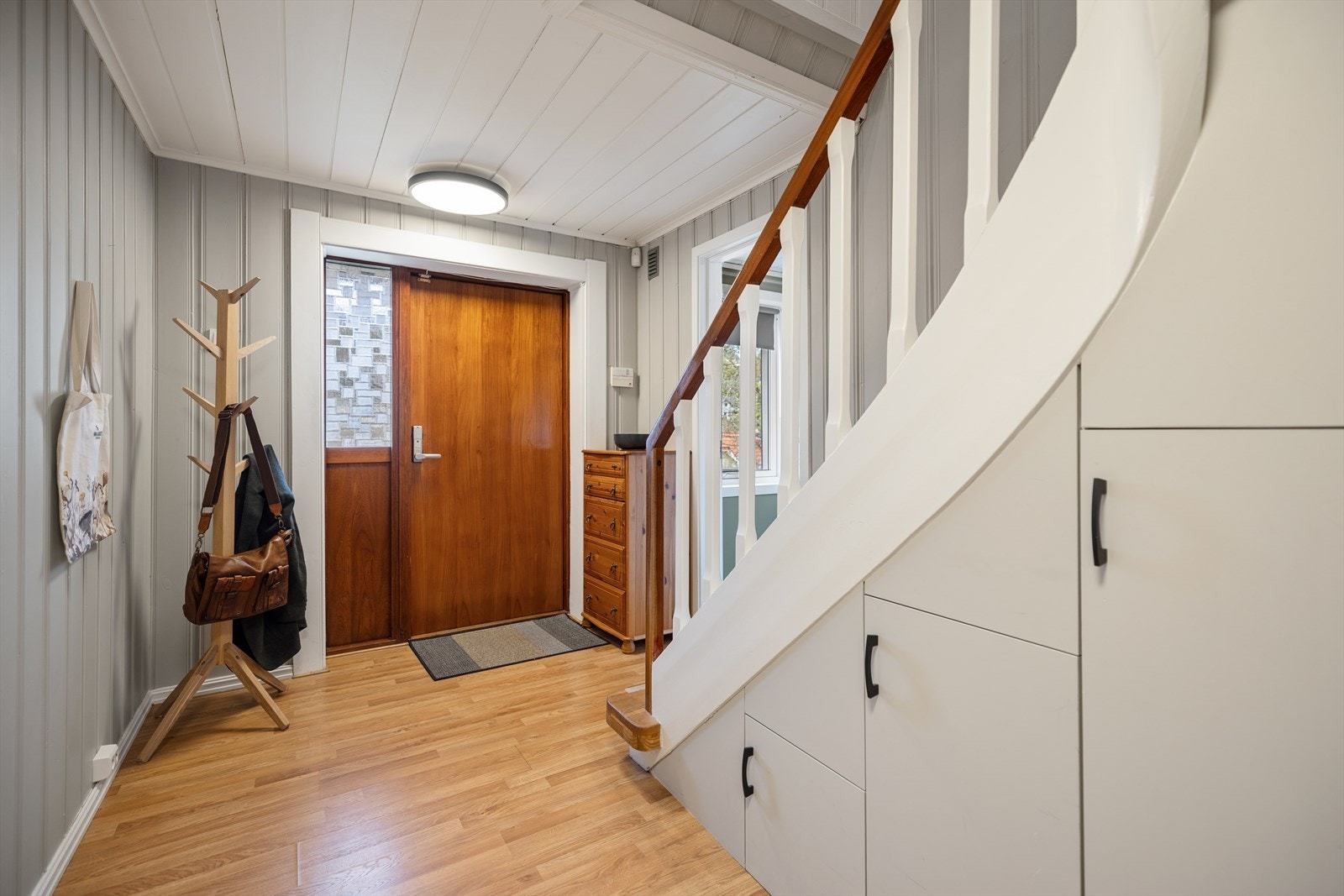 Entré i underetasjen med trapp som forbinder de to etasjene. Galleribilde