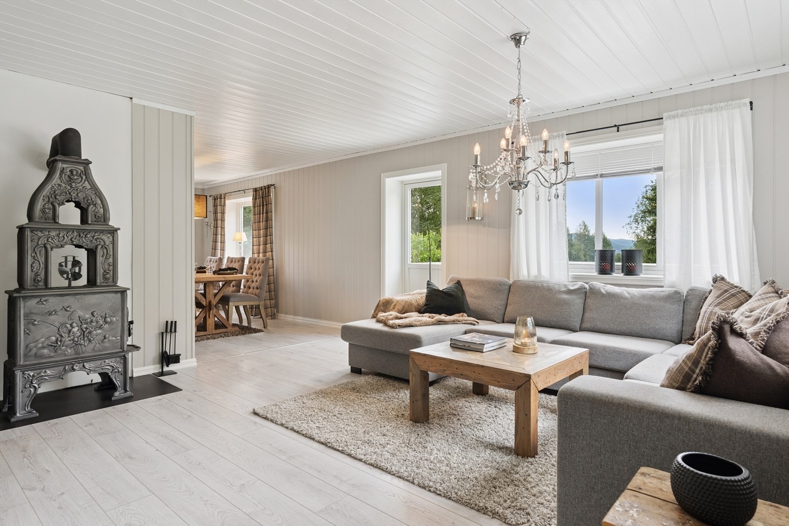 Det er god plass til flere sittegrupper, og en stilig Ulefoss etasjeovn er som et eget møbel i rommet. Galleribilde