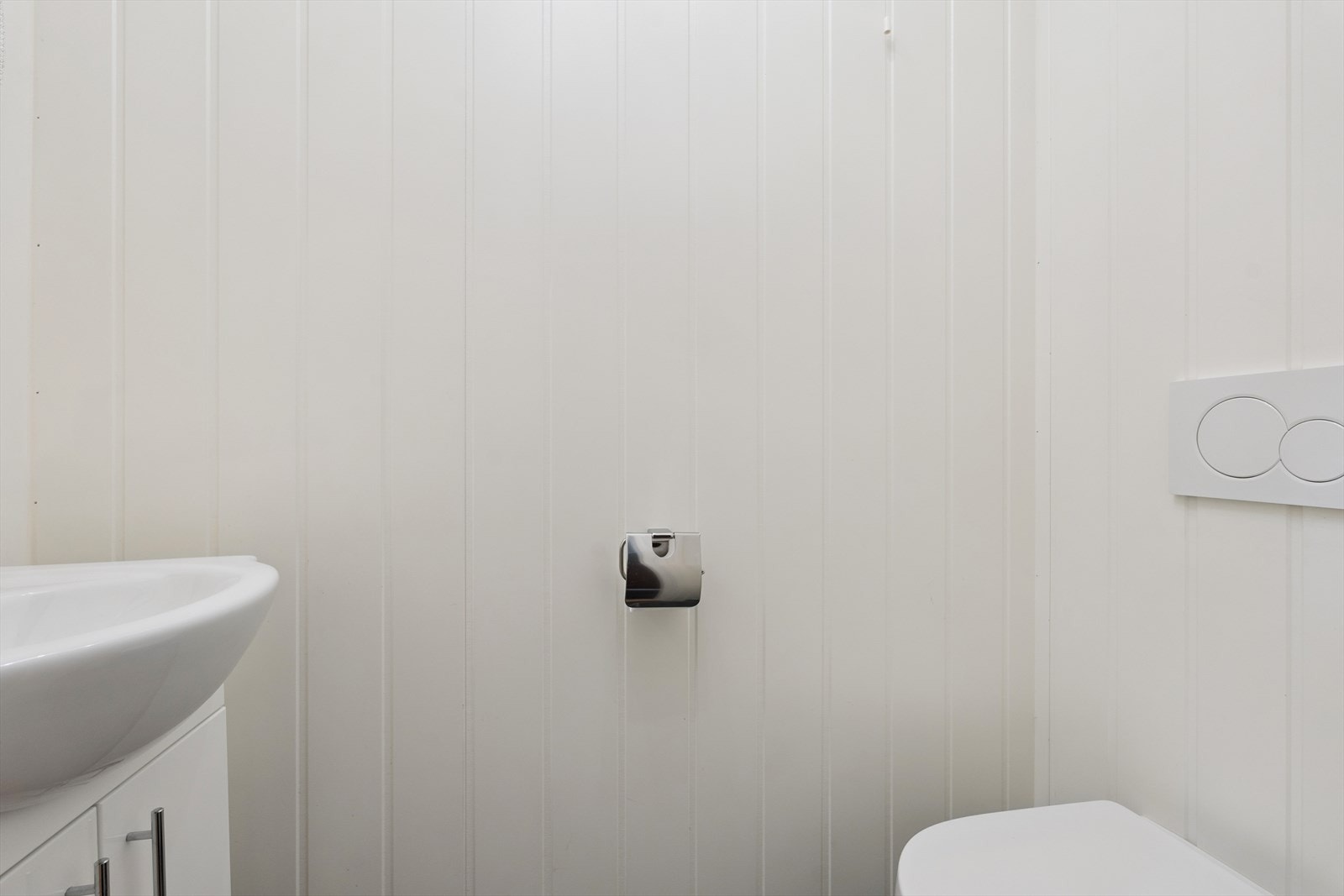 Fra hallen er det adkomst til toalettrom med porselensservant og vegghengt toalett med innebygd sisterne. Toalettrommet har flislagt gulv og varmekabler. Galleribilde