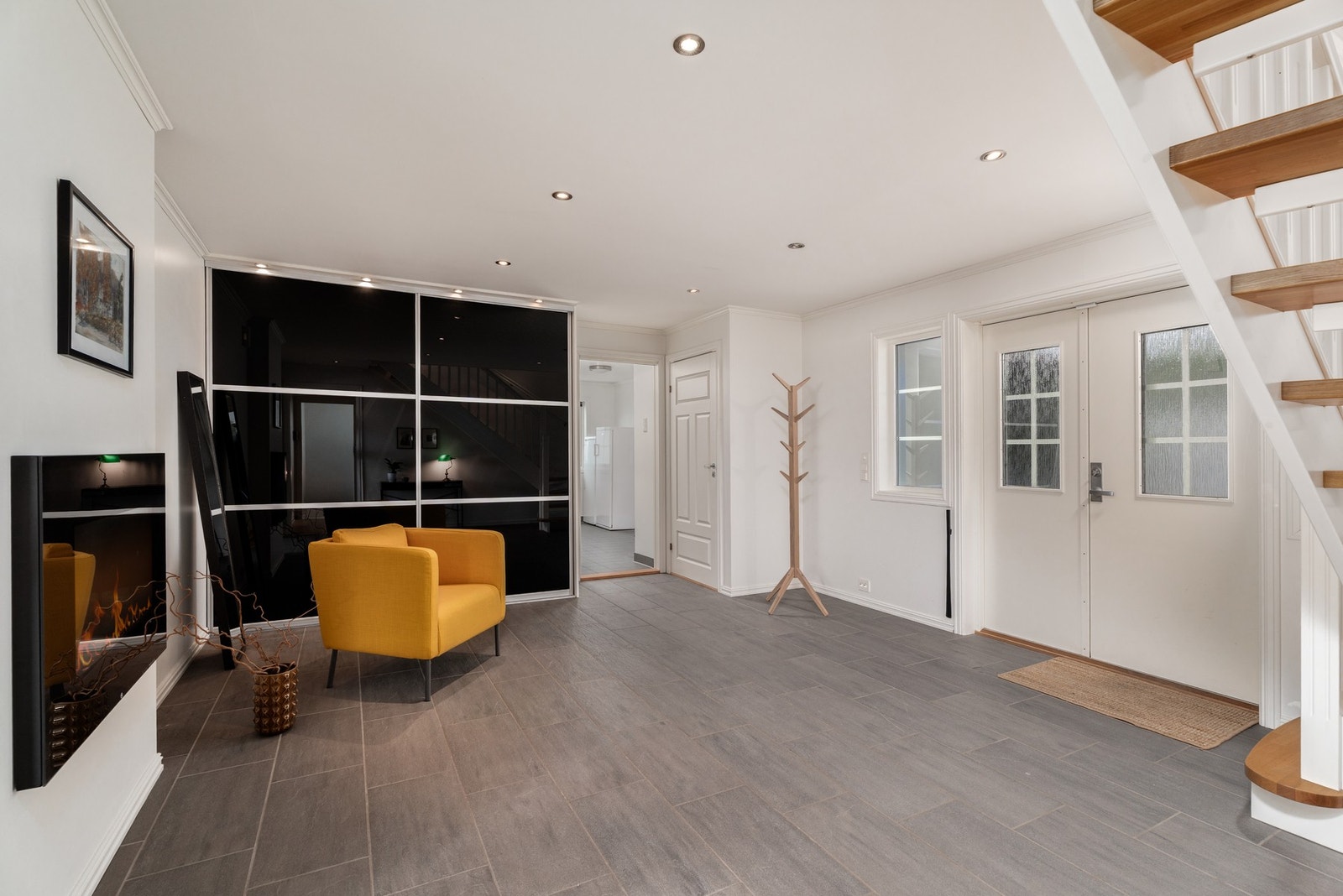 Velkommen inn! En lys og stor flislagt hall med dobbel skyvedørsgarderobe, downlights i himling og elektrisk peis Galleribilde